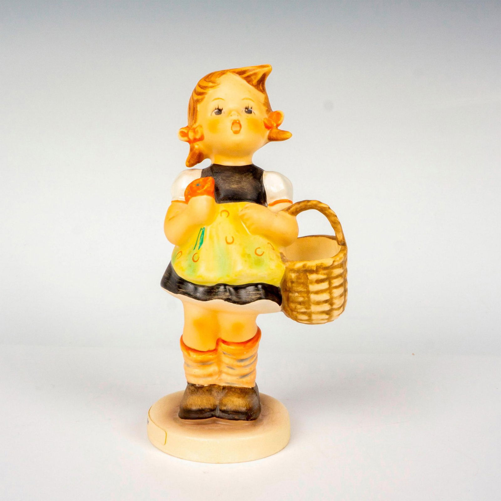 Goebel Hummel Figurine, Sister: Hand painted in matte finish modeled as a German girl carrying a basket. M. I. Hummel impressed backstamp. Goebel backstamp. Dimensions: 2.75"L x 2"W x 5.75"H Manufacturer: Goebel Hummel Country of Or