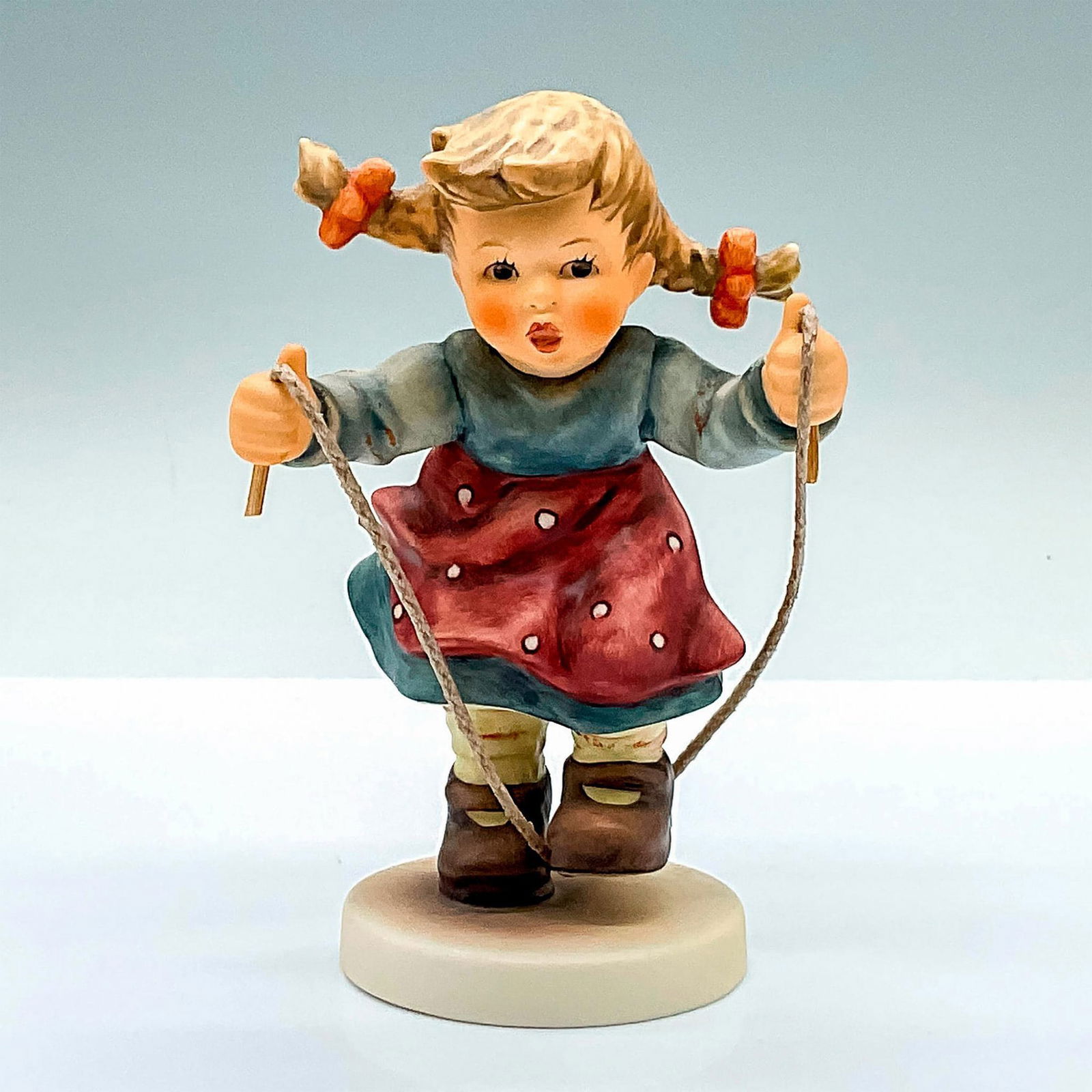 Goebel Hummel Figurine, Jump for Joy HUM 2084/A: Hand painted figure of a young girl playing with her jump rope. Goebel Hummel backstamp. Issued: 2001 Dimensions: 3.5"L x 3"W x 5.25"H Manufacturer: Goebel Hummel Country of Origin: Germany