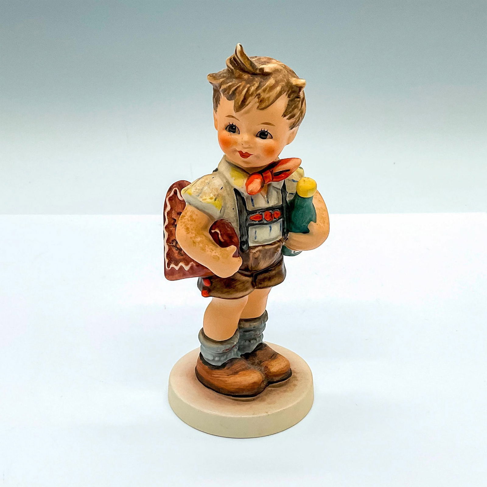 Goebel Hummel Figurine, Valentine Joy HUM 399: Exclusive edition celebrating the anniversary of the 1979 figure designed by Gerhard Skrobek. Hand painted figure of a young boy with a bottle of wine and a large heart. Goebel Hummel backstamp. Issue