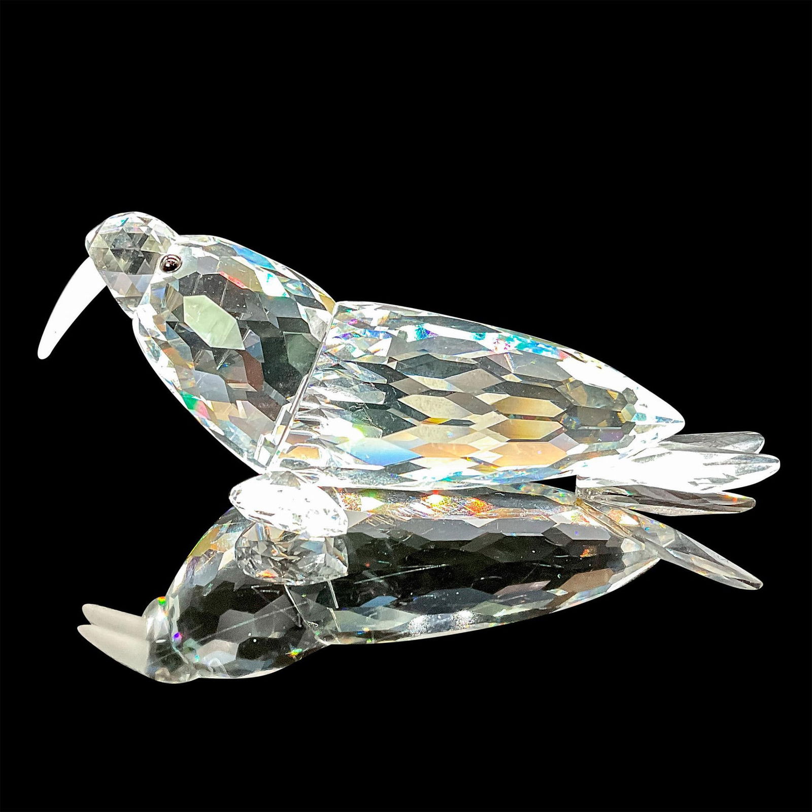 Swarovski Crystal Figurine, Walrus: This crystal walrus was part of the Kingdom of Ice and Snow group. The walrus is made from clear crystal, with black eyes and frosted tusks. This item has its original box which measures 6.5"H x 3.25"