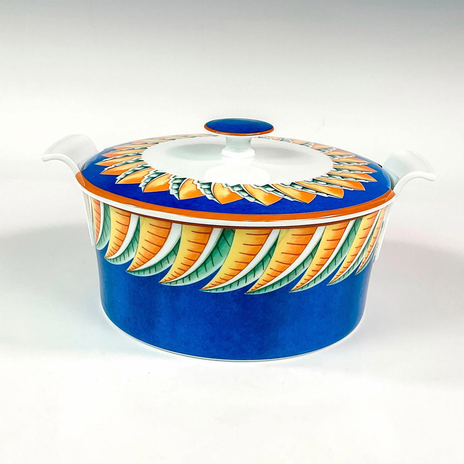 Lalique Porcelain Tureen with Lid, Soleil: Discontinued pattern. Elegant and lightweight porcelain tureen with swooped handles and knobbed lid. Design features a cerulean blue ground with abstract geometric yellow gold and green shapes radiati