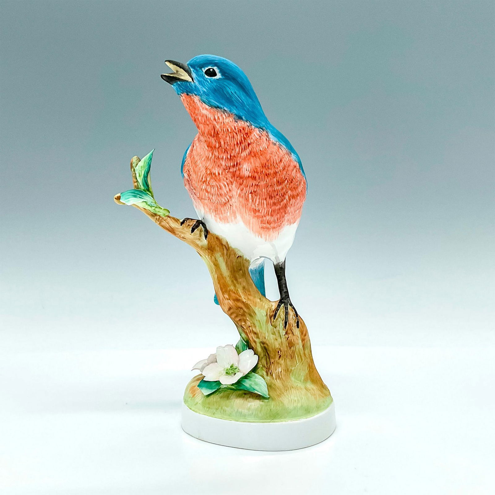 Crown Staffordshire Figurine, Blue Bird: Portrays a blue and peach bird perched on a branch with flowers growing on the base. Underside is Crown Staffordshire backstamped and signed. Artist: Doris Lindner Issued: 20th century Dimensions: 4.2