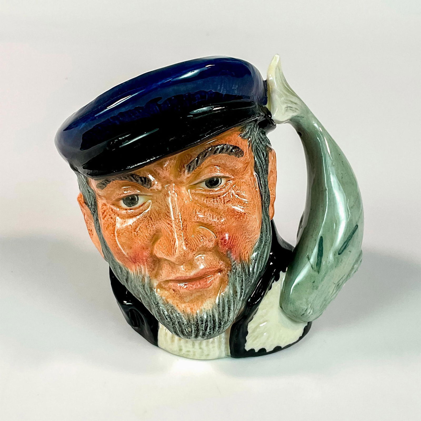 Captain Ahab D6506 - Small - Royal Doulton Character Jug: Blue cap; black coat; white sweater. Captain Ahab sailed the whaler, Pequod, in Herman Melville's great 19th century American classic, " Moby Dick" . He lost a leg and then his life in pursuit of the