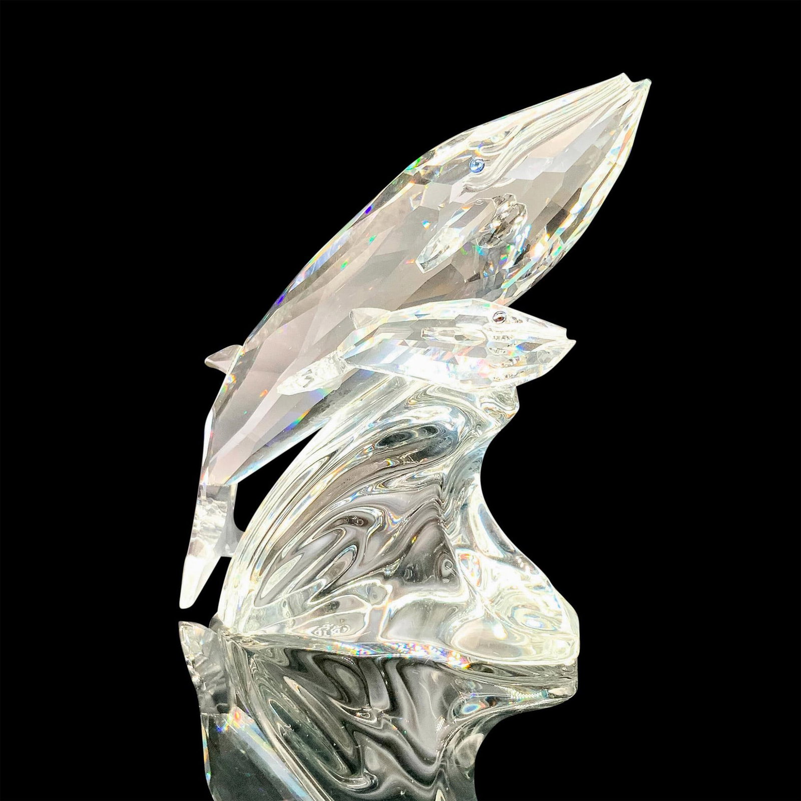 Swarovski Crystal Figurine, Care for Me: A clear crystal figurine of a mother whale and her young swimming side by side. Blue crystals used for the eyes. Swarovski backstamp. This item has its original box. Certificate of Authenticity includ