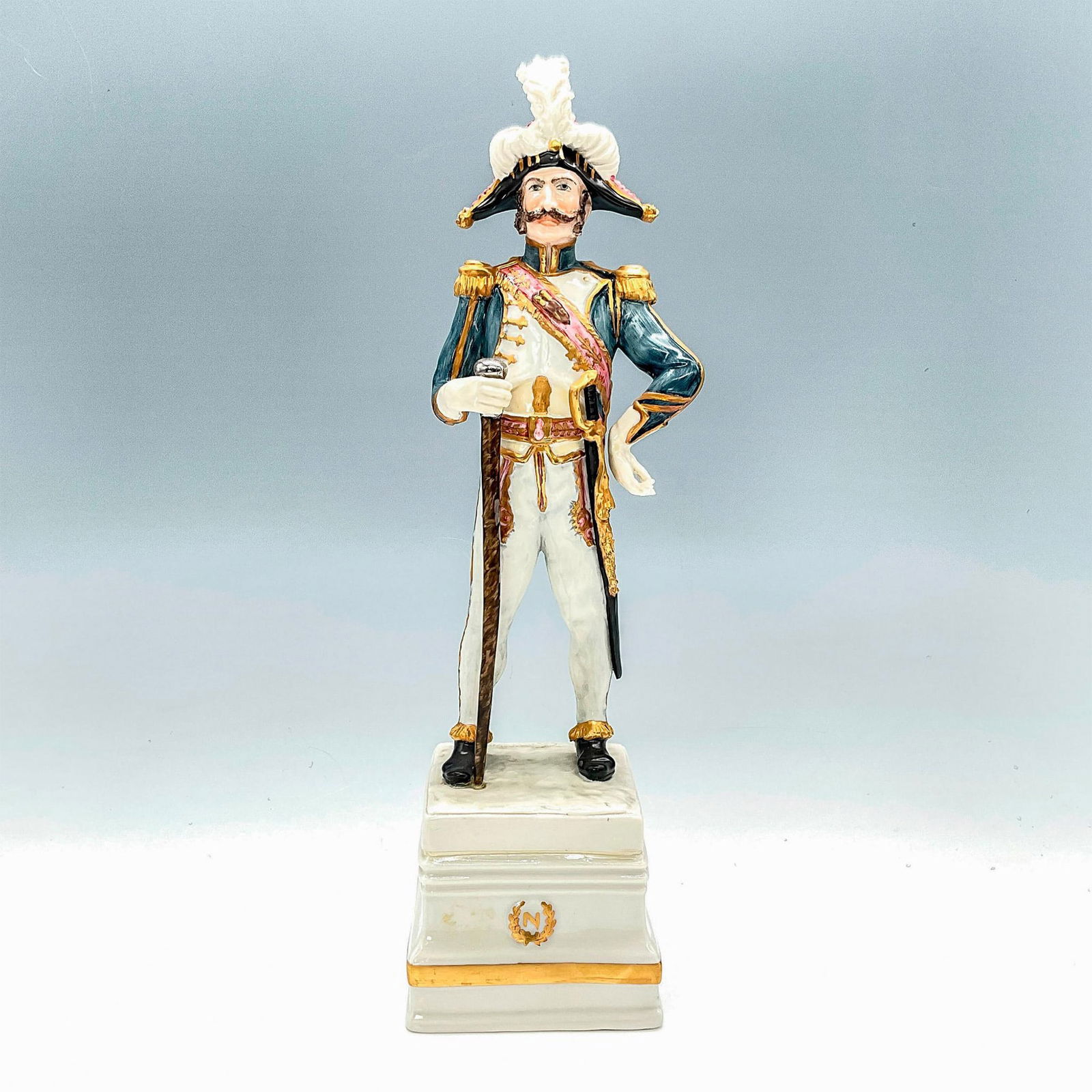 Cacciapuoti Porcelain Napoleonic Figurine, Tambour Major: A Guido Cacciapuoti figurine depicting Napoleonic era imperial French soldier on a raised porcelain pedestal with gilt N within a wreathed medallion to front, and name of piece inscribed to verso of p
