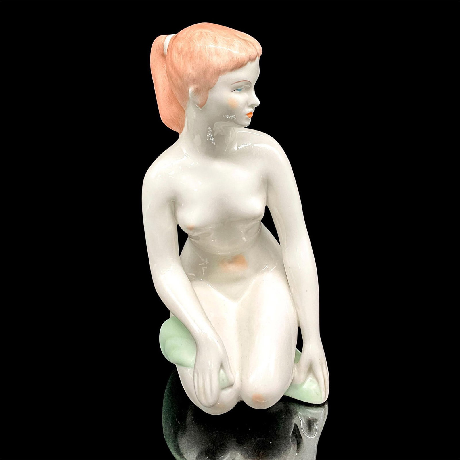 Aquincum Porcelain Nude Sculpture: Beautiful Hungarian art deco sculpture of a young woman kneeling. She holds a green bath towel to her knee. Vintage item. Glossy finish. Budapest Aquincum backstamp. Dimensions: 5.25"L x 4"W x 9"H Man