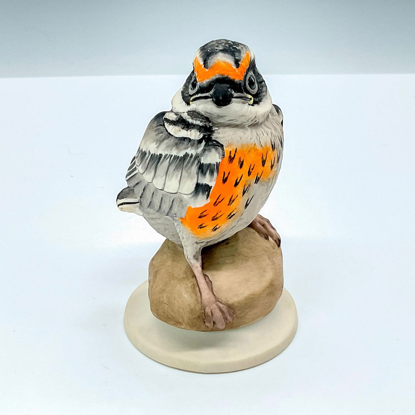 Edward Marshall Boehm Bird, Fledgling Blackburnian Warbler: Edward Marshall Boehm Studios Porcelain Figurine Bird, Fledgling Blackburnian Warbler #478 K with grey and orange breast, standing on rock. Boehm backstamp. Issued: 20th Century Dimensions: 2.5"L x 2.