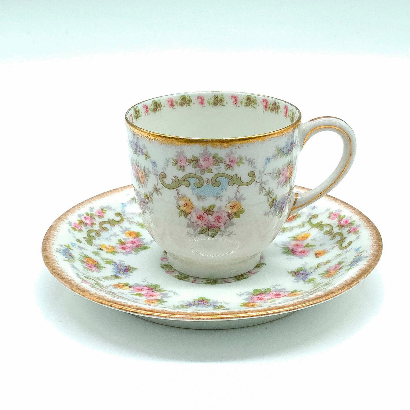 Jean Pouyat Limoges Floral Demitasse and Saucer Set: Made for Mermod, Jaccard & King Jewelry Co. in New York and St. Louis. White porcelain with flowers and gold trim. Espresso cup: 3"L x 2.25"W x 2"H. Saucer: 4.5"dia. Country of Origin: France
