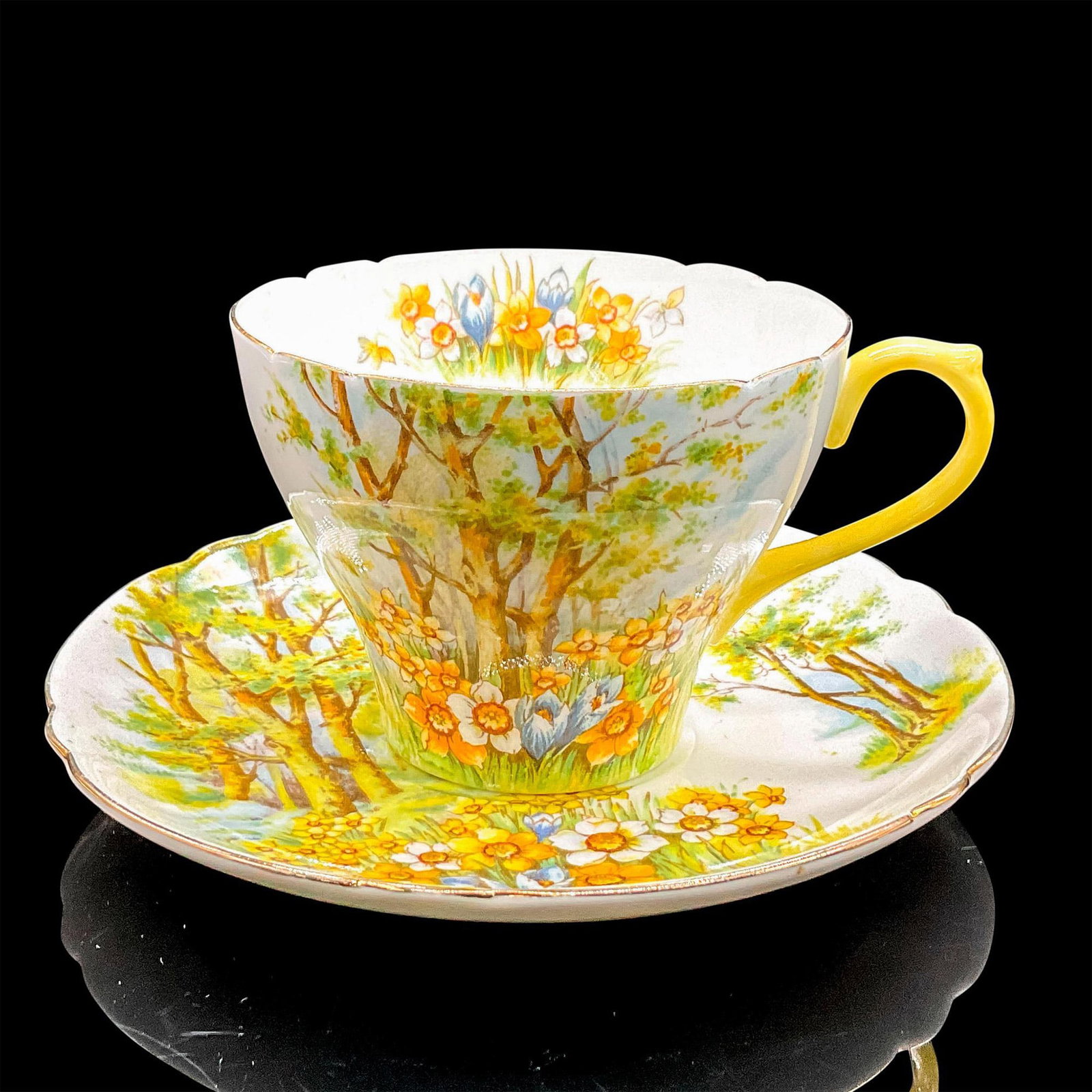 2pc Shelley England Cup and Saucer, Daffodil Time: Vintage white bone china with pleasant yellow, white and blue flowers, gilt rims. New Cambridge shape. Tea cup 4"L x 3.5"W x 2.5"H. Saucer 0.75"H x 5.5"dia. Shelley England backstamp. Manufacturer: Sh