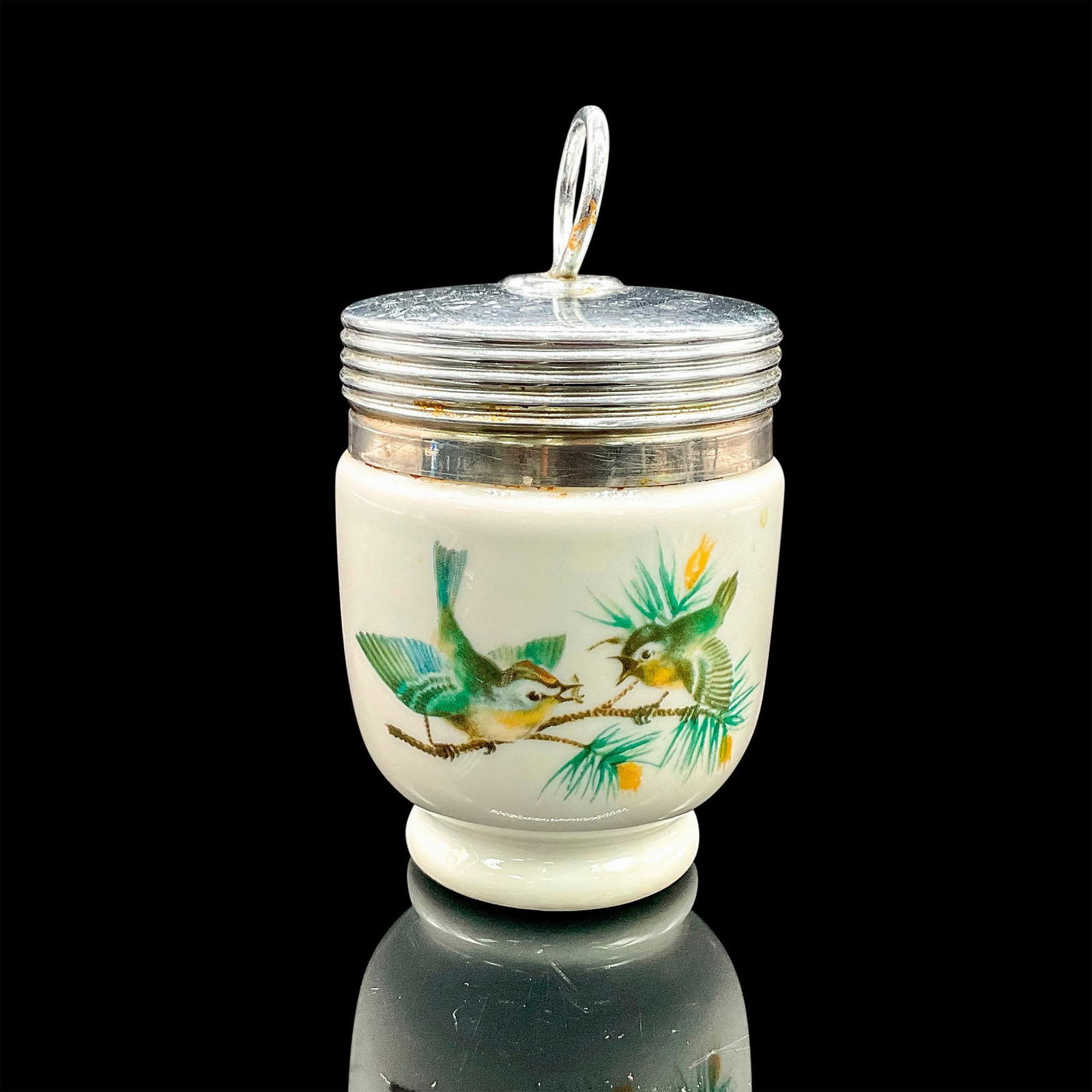 Royal Worcester Egg Coddler, Playful Birds: Small white porcelain oven-safe egg cup with silvertone lid and active birds motif. Royal Worcester backstamp. Dimensions: 3.75"H x 2"dia Manufacturer: Royal Worcester Country of Origin: England