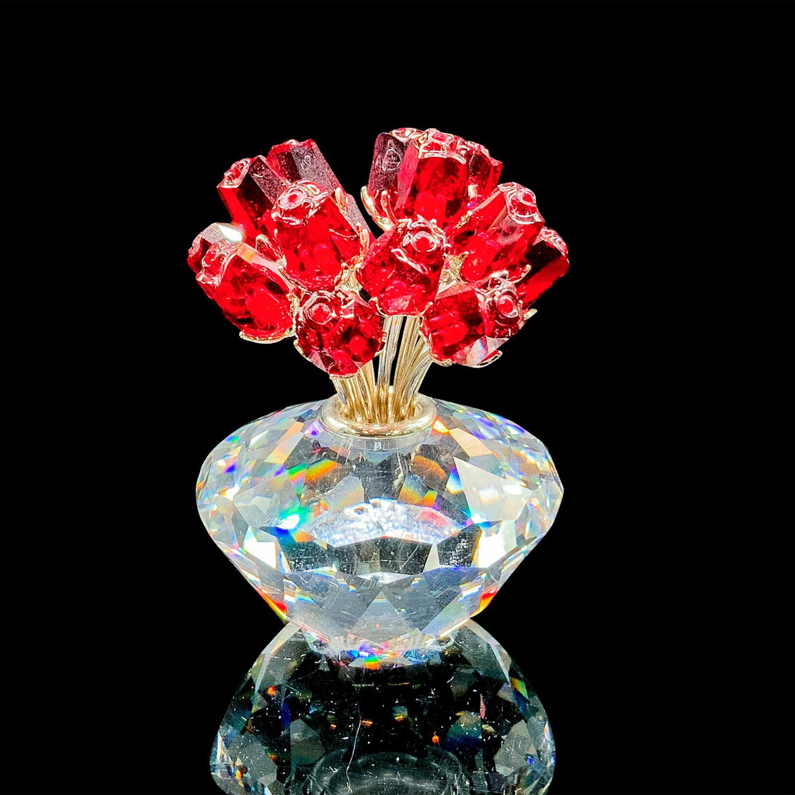 Swarovski Crystal Figurine, The Vase of Roses: Lead crystal, depicting a clear vase full of red roses. Item includes original box measuring 4.75"L x 4.75"W x 4"H. Issued: 2002 Dimensions: 2"L x 2"W x 2.75"H Manufacturer: Swarovski Country of Origi