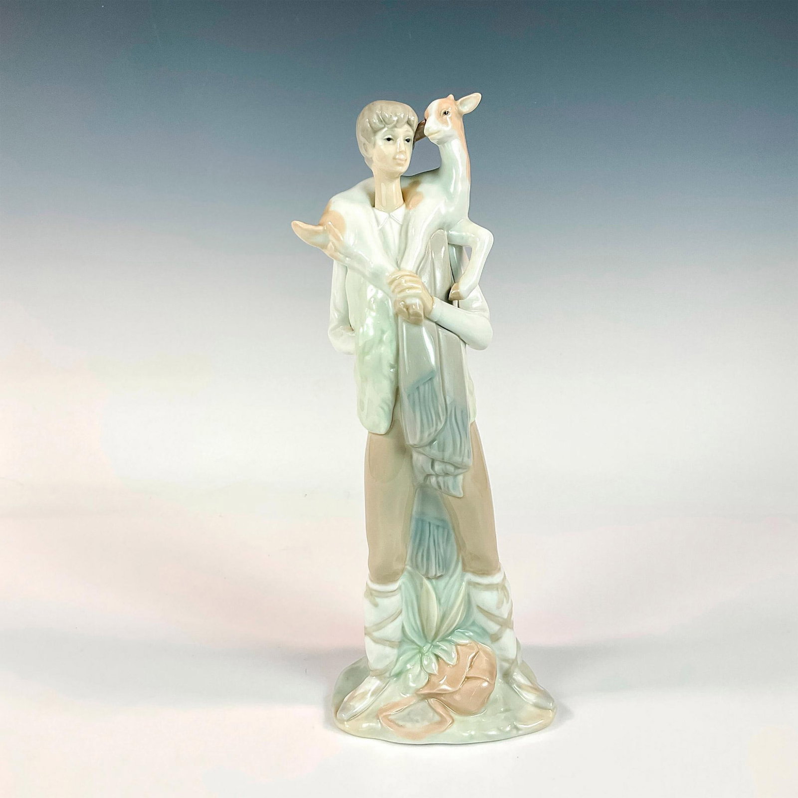 Shepherd Boy with Goat 1004506 - Lladro Porcelain Figurine: Beautiful gloss finished character colored in soft cream and bone. Lladro backstamp. Imprint number 2. Dimensions: 4"L x 3.25"W x 11"H Manufacturer: Lladro Country of Origin: Spain