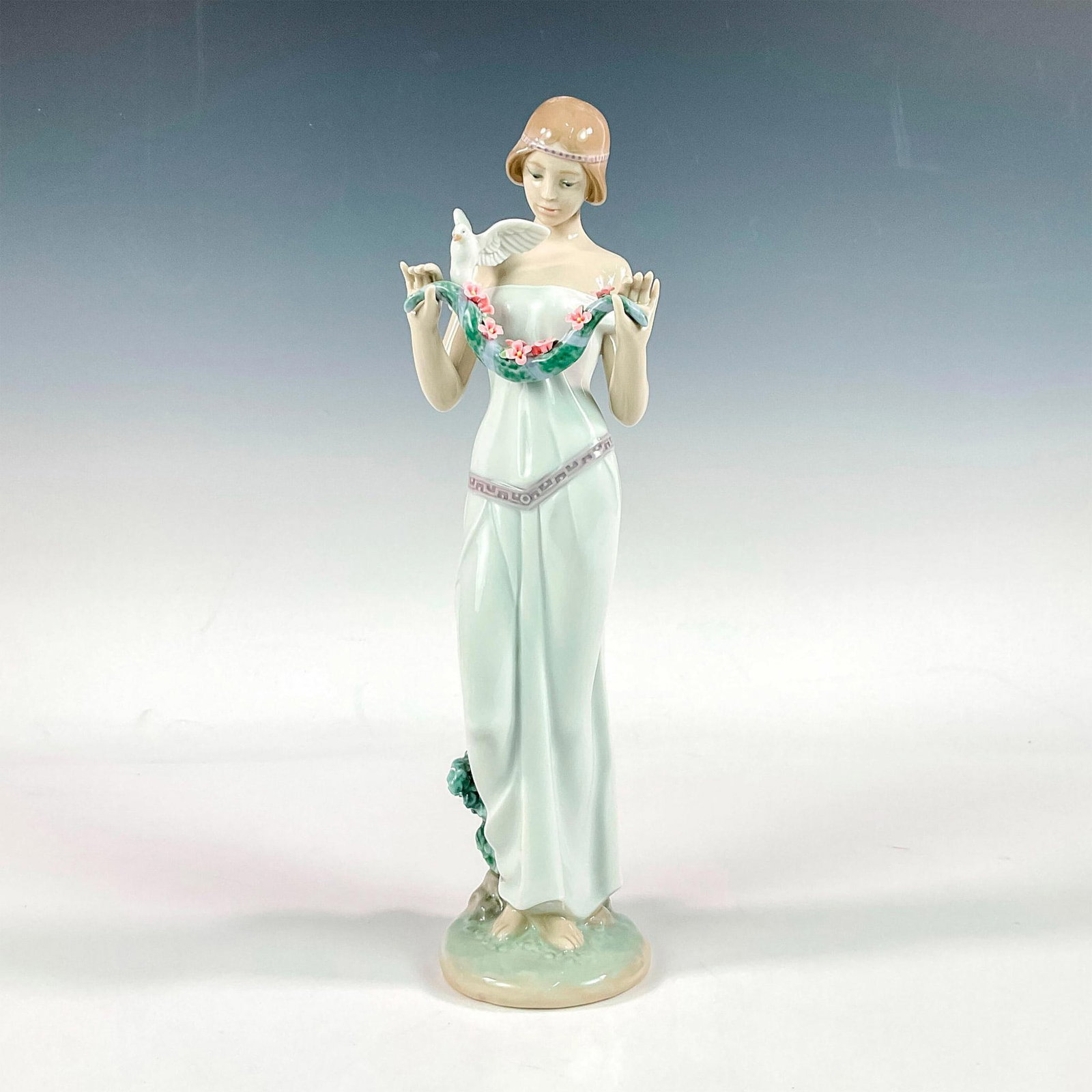Sweet VIctoria 1008510 - Lladro Porcelain Figurine: Glossy finish; Lladro backstamp. Artist: Miguel Angel Santaeulalia Issued: 2010 - 2017 Dimensions: 12.25"H x 3.5"W Manufacturer: Lladro Country of Origin: Spain