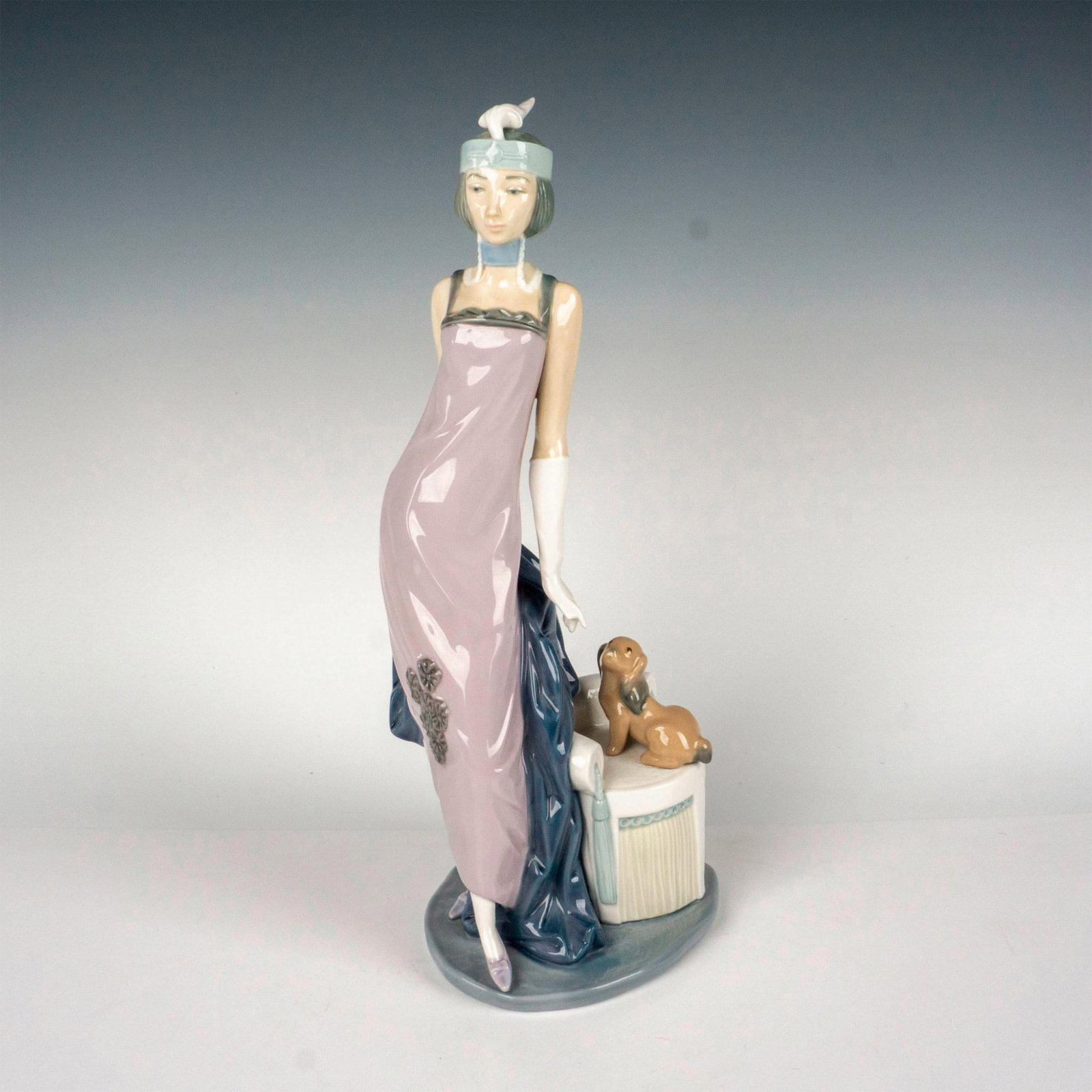 Couplet Lady 1005174 - Lladro Porcelain Figurine: Glazed figure of a 1920 lady with a dog. Lladro backstamp. This item has its original box: 15.75"L x 6.5"W x 6.5"H. Artist: Vincente Martinez Issued: c. 1982-1993 Dimensions: 5.5"L x 4.75"W x 13.25"H 