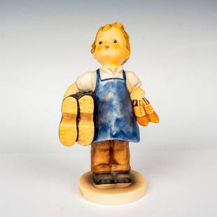 Goebel Hummel Figurine, Boots: Hand painted in matte finish modeled as a young working boy holding boots. M. I. Hummel impressed backstamp. Goebel backstamp. Dimensions: 3.75"W x 6.75"H Manufacturer: Goebel Hummel Country of Origin