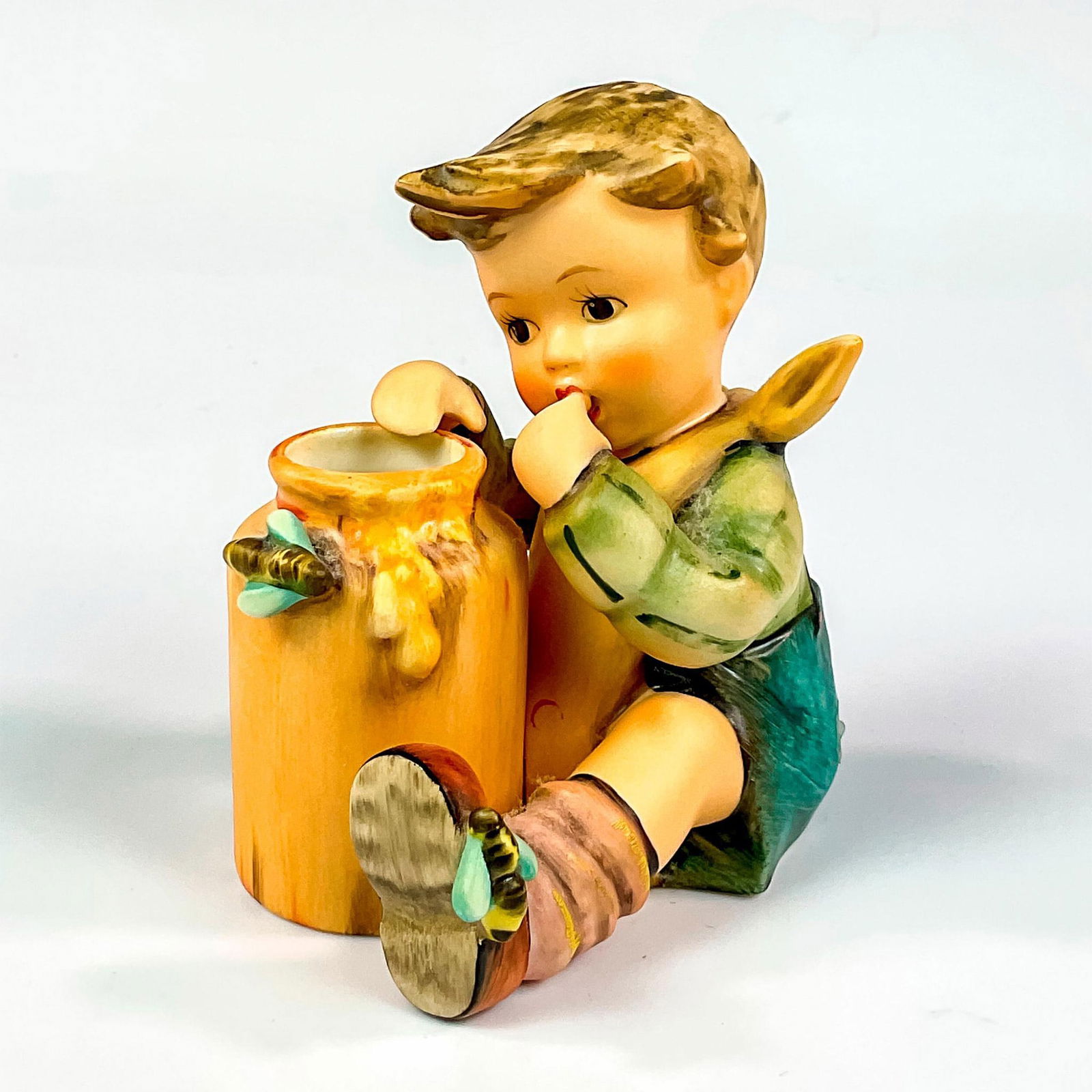 Goebel Hummel Porcelain Figurine, Honey Lover HUM 312/I: Exclusive edition hand painted figure celebrating the 15th year anniversary of the 1955 molded designed by master sculptor Helmut Wehlte. Goebel Hummel backstamp. Issued: c. 1990-1999 Dimensions: 3.25