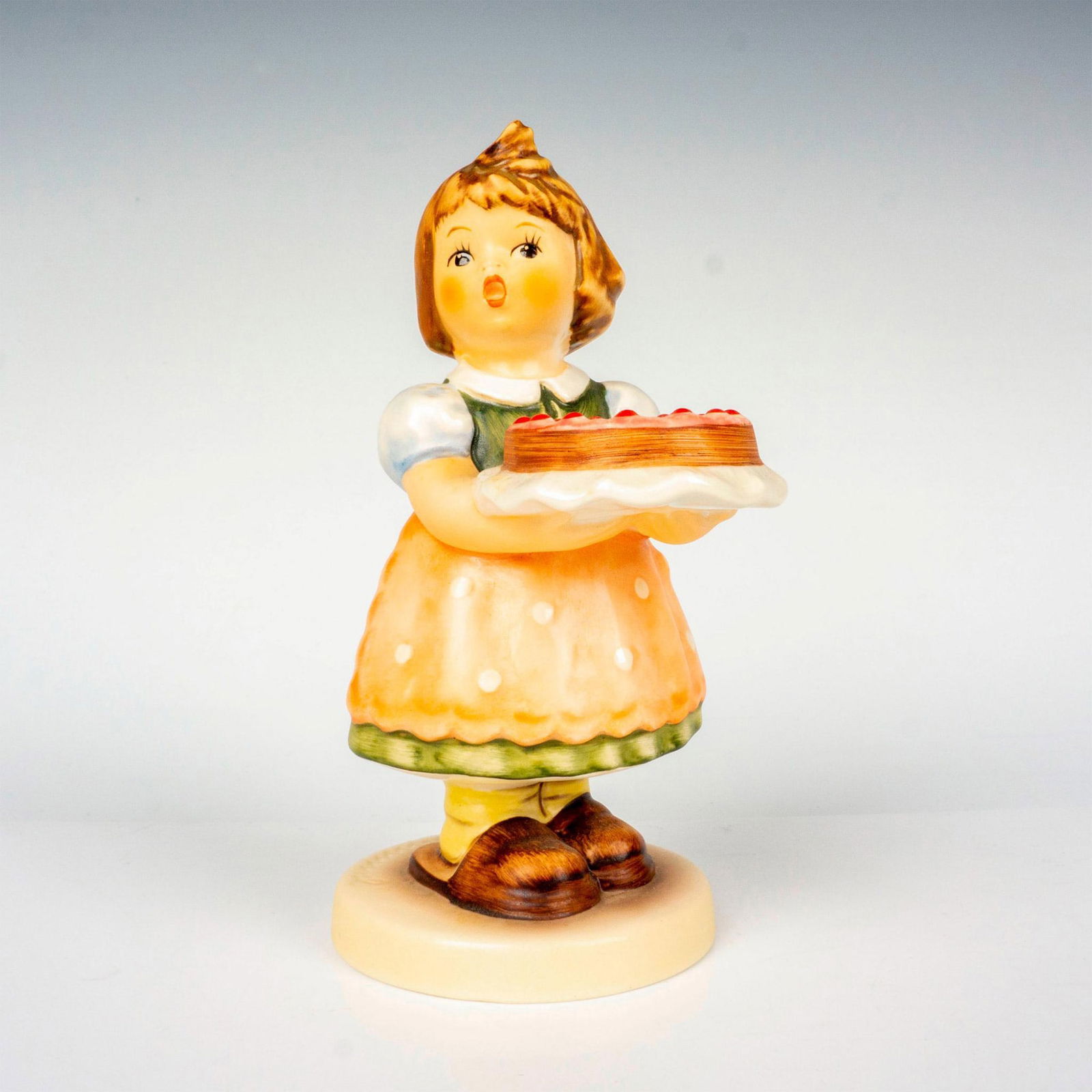 Goebel Hummel Figurine, Birthday Candle: Hand painted in matte finish, designed to commemorate Canada's 130th birthday. M. I. Hummel impressed backstamp. Goebel backstamp. Certificate of Authenticity included. Dimensions: 2.5"W x 5.5"H Manuf