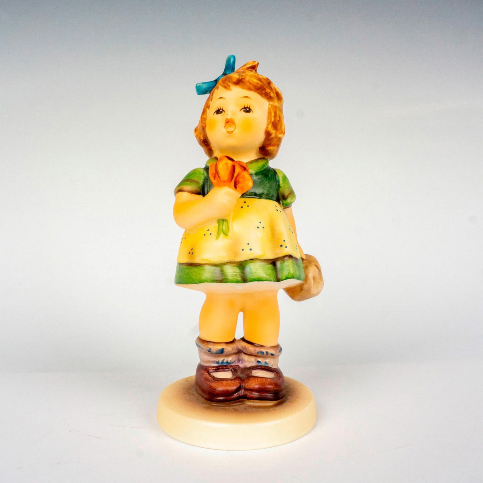 Goebel Hummel Figurine, The Suprise: Hand painted in matte finish modeled as a young girl carrying a bouquet of flowers. M. I. Hummel impressed backstamp. Goebel backstamp. Issued: 1981 Dimensions: 2.5"W x 6.5"H Manufacturer: Goebel Humm