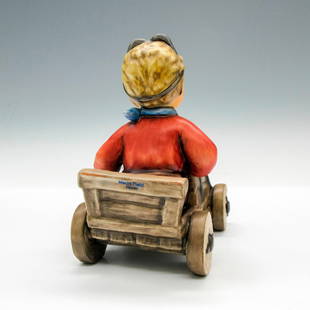 Goebel Hummel Porcelain Figurine, Soap Box Racer 2121: Hand painted racer, colored in browns, red and blue. Hummel backstamp. Issued: 1935 - 1949 Dimensions: 4.25"L x 3.25"W x 5"H Manufacturer: Goebel Hummel Country of Origin: Germany