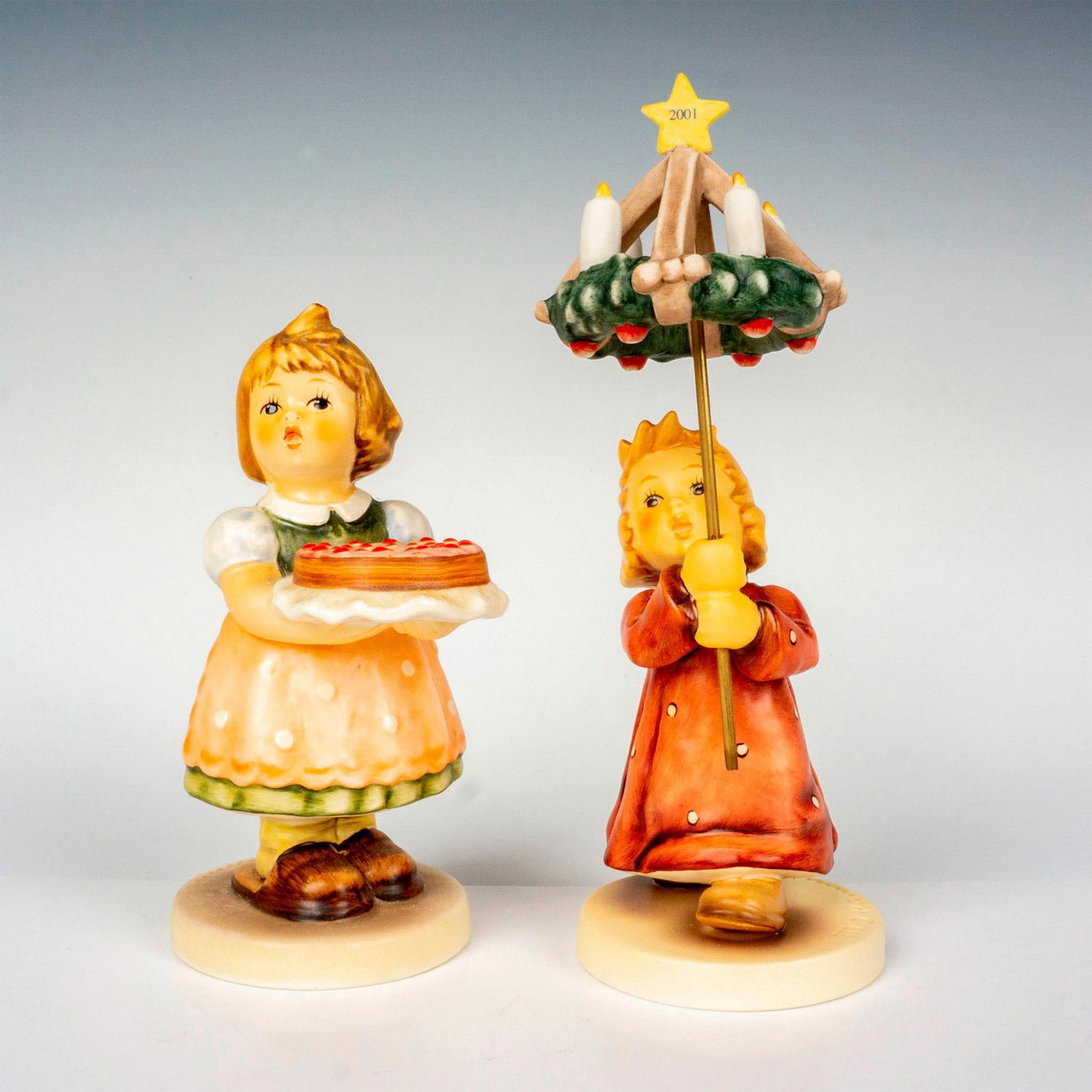 2pc Goebel Hummel Figurines: Hand painted in matte finish, exclusive and special edition pieces titled Birthday Candle and Christmas By Candlelight. M. I. Hummel impressed backstamp. Goebel backstamp. Artist signed on bottom. Bir