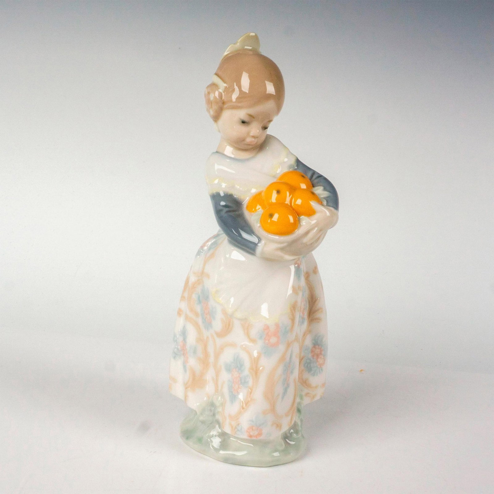 Girl From Valencia 1004841 - Lladro Porcelain Figurine: Glossy finish; Lladro backstamp. Includes original box. Box measures: 10.25"L x 5.25"W x 4.75"H. Artist: Fulgencio Garcia Issued: 1973 - 2017 Dimensions: 6.75"H x 2.75"W Manufacturer: Lladro Country o