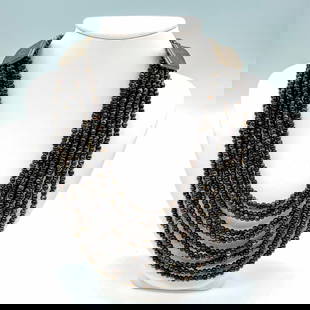 Cesaree Paris Ten Strand Dark Beaded Necklace: Ten strands of small dark opalescent bronze and black tone beads with two bronze pieces that have the Cesaree Paris stamp. Dimensions: 17"L Manufacturer: Cesaree Paris Country of Origin: France