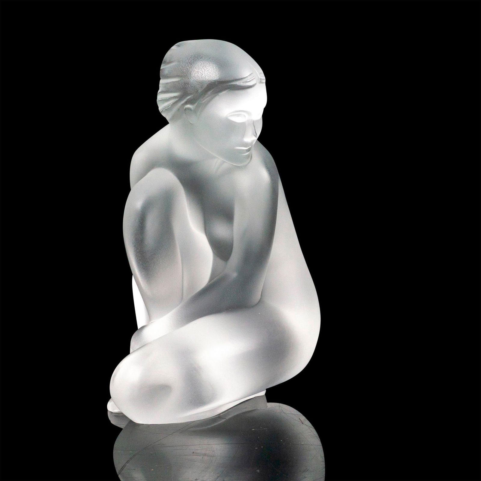 Lalique Crystal Figurine, Venus Nude: A frosted crystal figural modeled as a nude woman kneeling. Lalique France etched backstamp. Dimensions: 2.5"L x 3"W x 4"H Manufacturer: Lalique Country of Origin: France