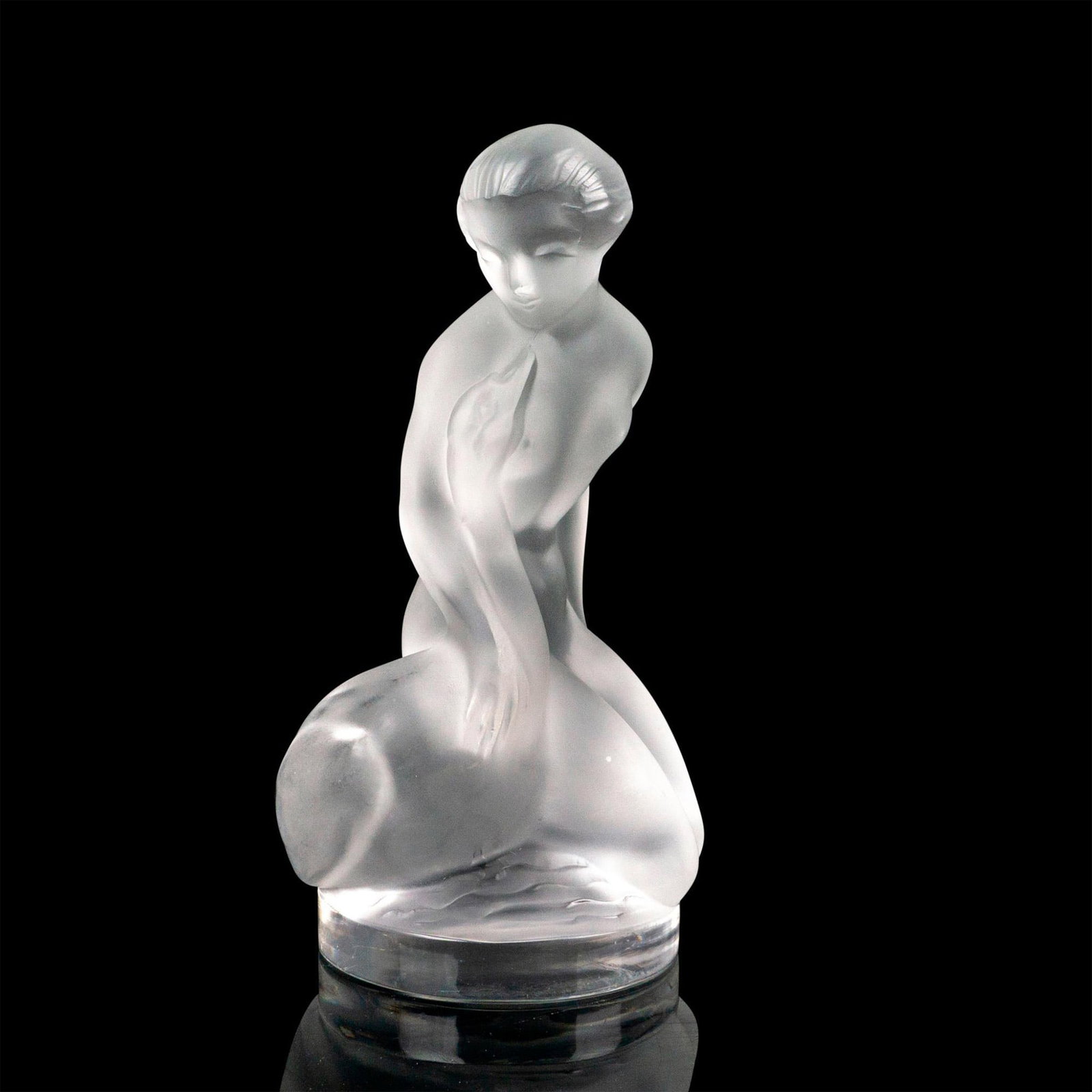 Lalique Crystal Figurine, Leda and Swan: Frosted crystal figure depicting a nude woman seated next to a swan. Lalique France etched backstamp. Dimensions: 2.5"W x 4.5"H Manufacturer: Lalique Country of Origin: France