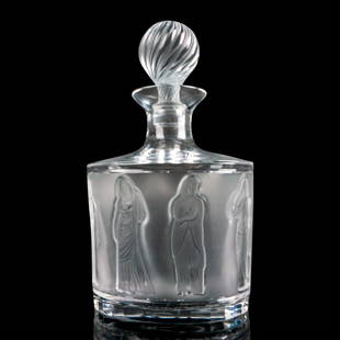 Lalique Crystal Whiskey Decanter , Femmes: Staggering decanter with stopper decorated with frosted raised woman. Marked Lalique France to bottom. Dimensions: 5.25”L x 4”W x 10”H Manufacturer: Lalique Country of Origin: France