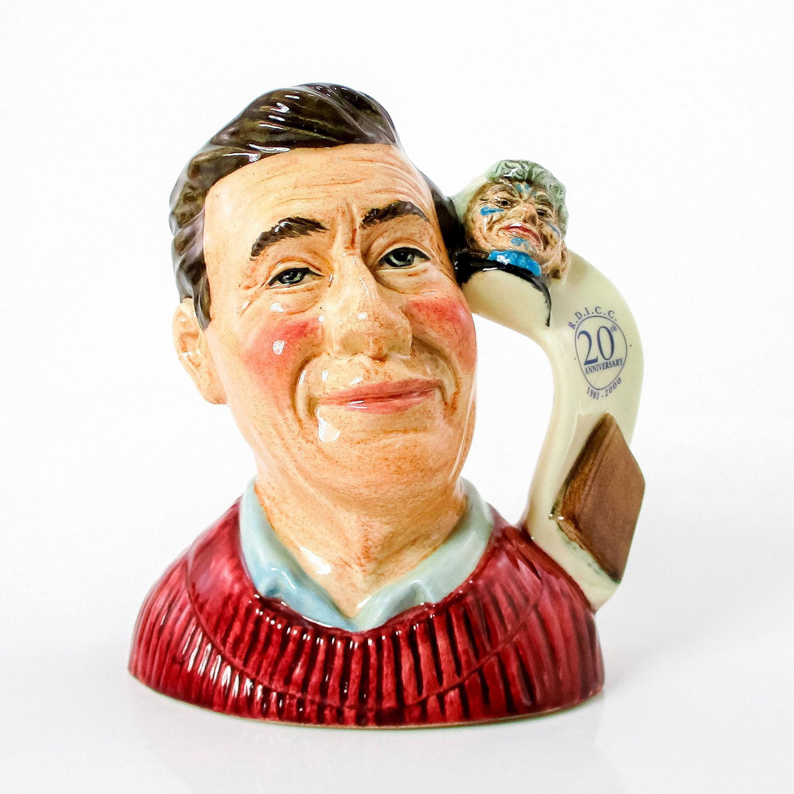 Jug Collector D7147 - Small - Royal Doulton Character Jug: White shirt; rose sweater. Series: RDICC. Royal Doulton and RDICC 20th Anniversary backstamp. Comes with certificate. Artist: Robert Tabbenor Issued: 2000 - 2000 Dimensions: 4.75"H Country of Origin: