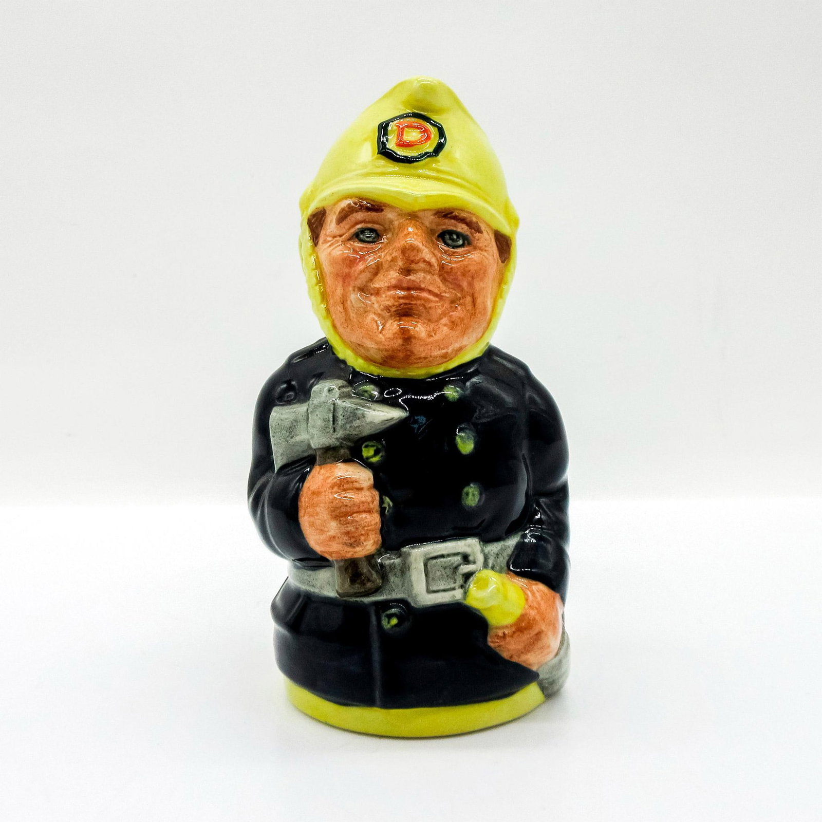 Fred Fearless the Fireman D6809 - Royal Doulton Toby Jug: Dark blue uniform with green buttons; yellow helmet. Series: The Doultonville Collection. Royal Doulton backstamp. Artist: William K. Harper Issued: 1989 - 1991 Dimensions: 4"H Manufacturer: Royal Do