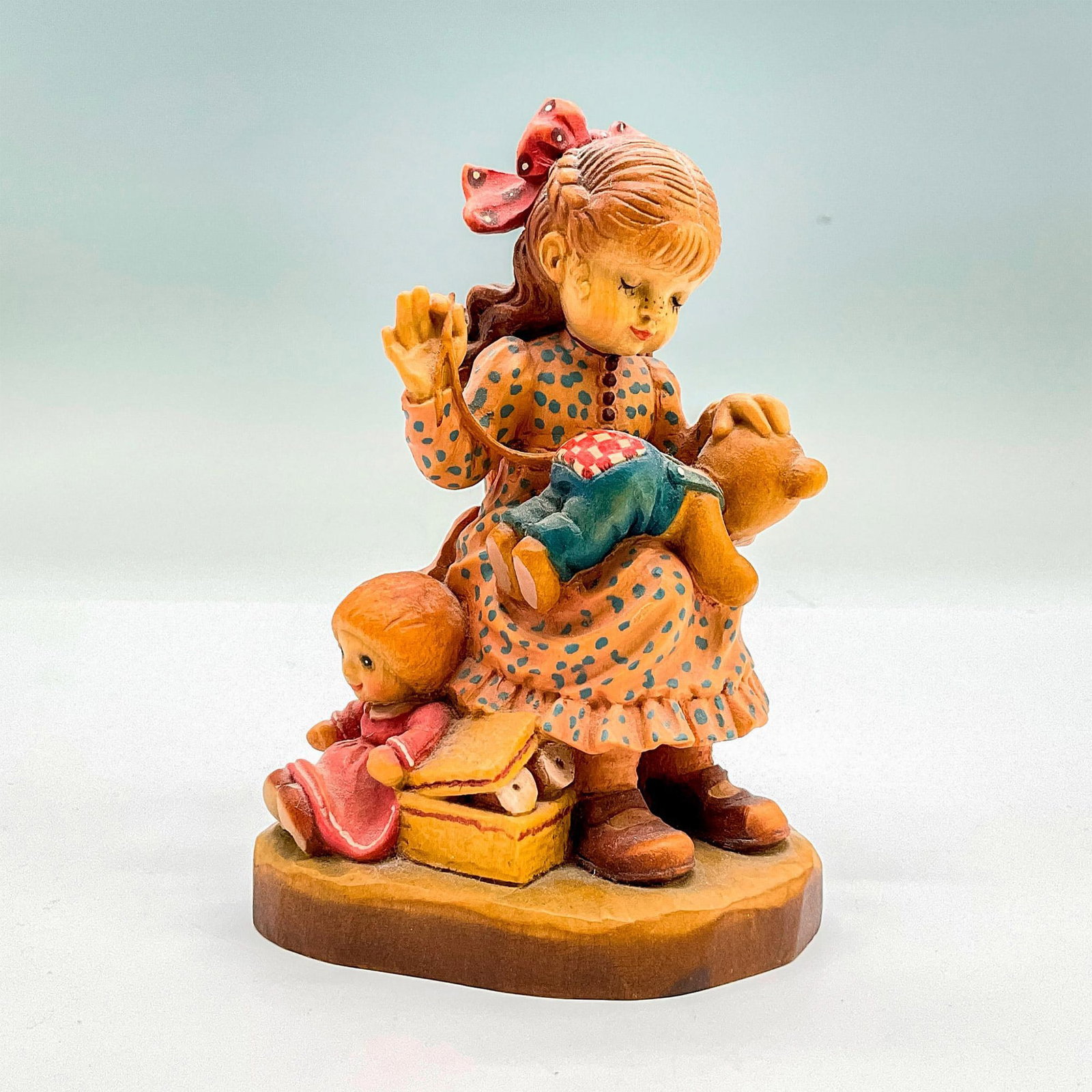 Anri Italy Wood Carved Figurine, Good As New: Charming painted figure of a young girl sewing her teddy bear. In hues of earthy orange, red, pink, tan and brown. Anri metal logo emblem affixed to base. Design Valentine backstamp. Sarah Kay engrave