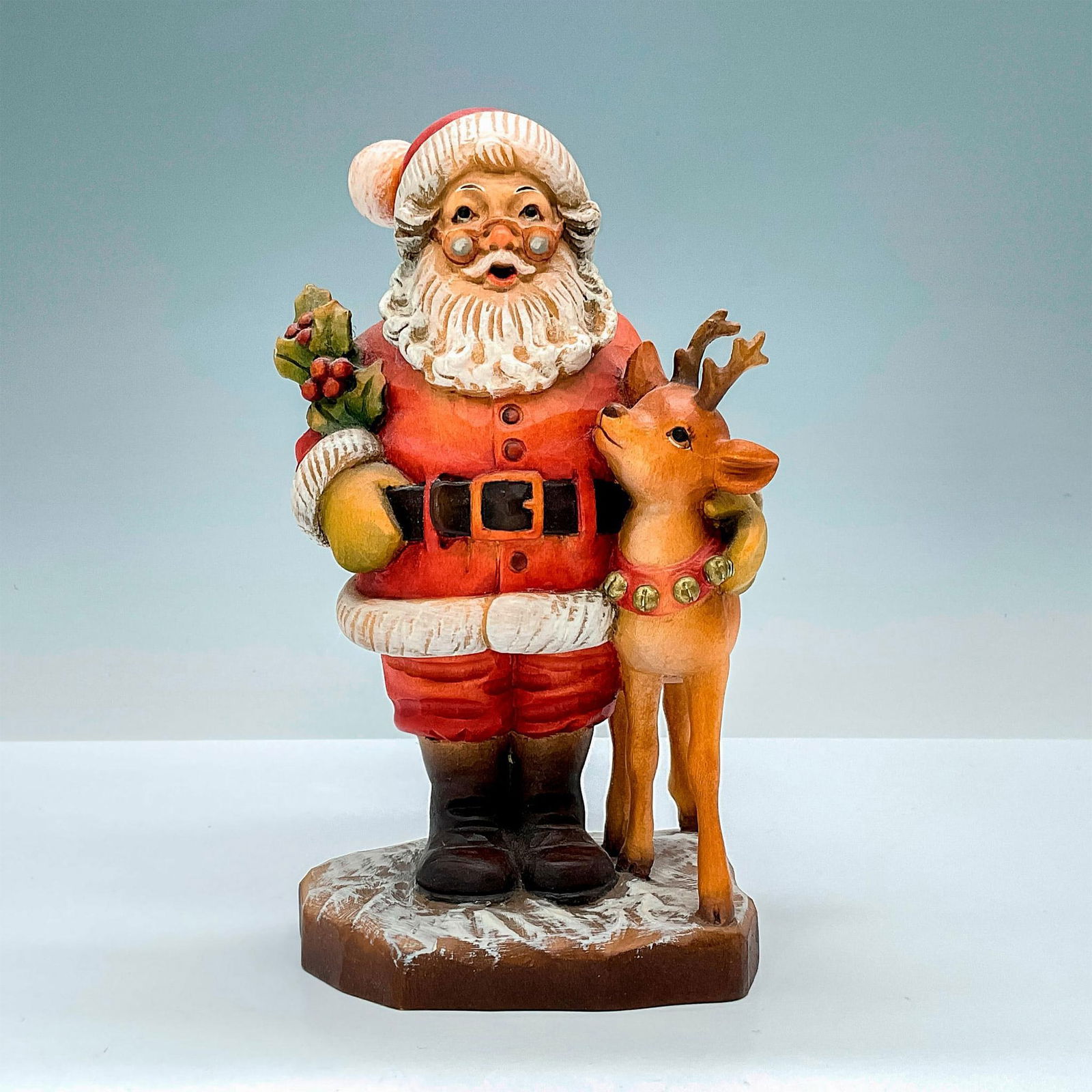 Anri Italy Wood Carved Figurine, Kris Kringle: Adorable painted figure of Santa with reindeer. In hues of earthy red, green, tan and brown. Anri metal logo emblem affixed to base. Design John Sands backstamp. Sarah Kay engraved to back of base. Di