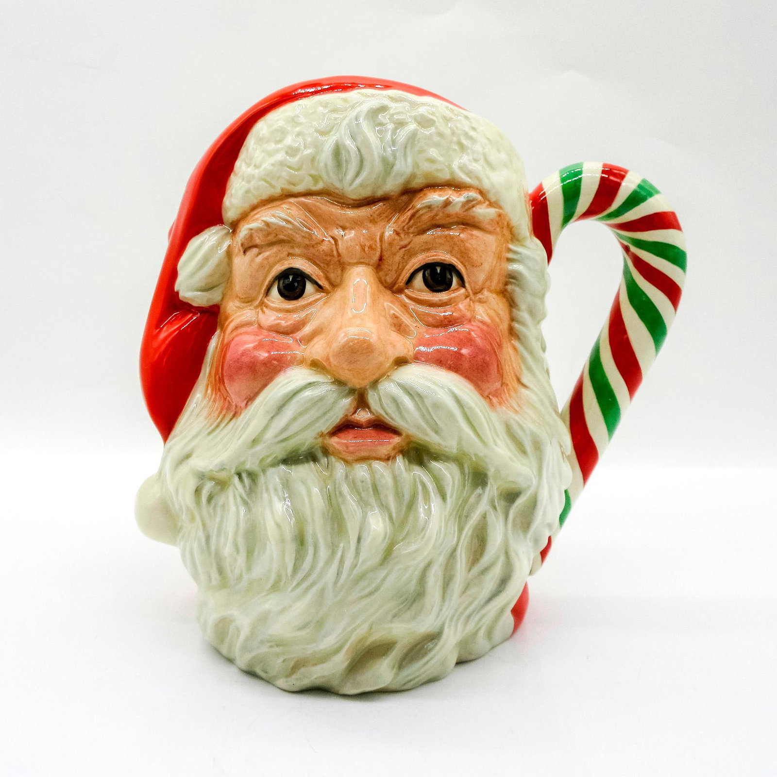 Santa Claus D6840 (Red - Green and White Handle) - Large - Royal Doulton Character Jug: Variation Two. Red and white coloration. Tricolor candy cane handle. Royal Doulton backstamp. Special Edition of 1000 pieces. Artist: Michael Abberley Issued: 1989 Dimensions: 7.5"H Manufacturer: Roya