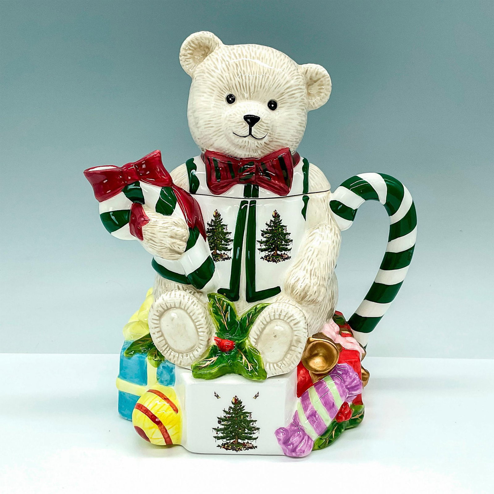 Spode Bone China Figural Teapot, Christmas Tree Teddy Bear: This Spode teapot is shaped like a teddy bear with a Christmas tree pattern on its vest sitting on a pile of presents. Spode backstamp. Dimensions: 8"L x 6"W x 9"H Manufacturer: Spode Country of Origi
