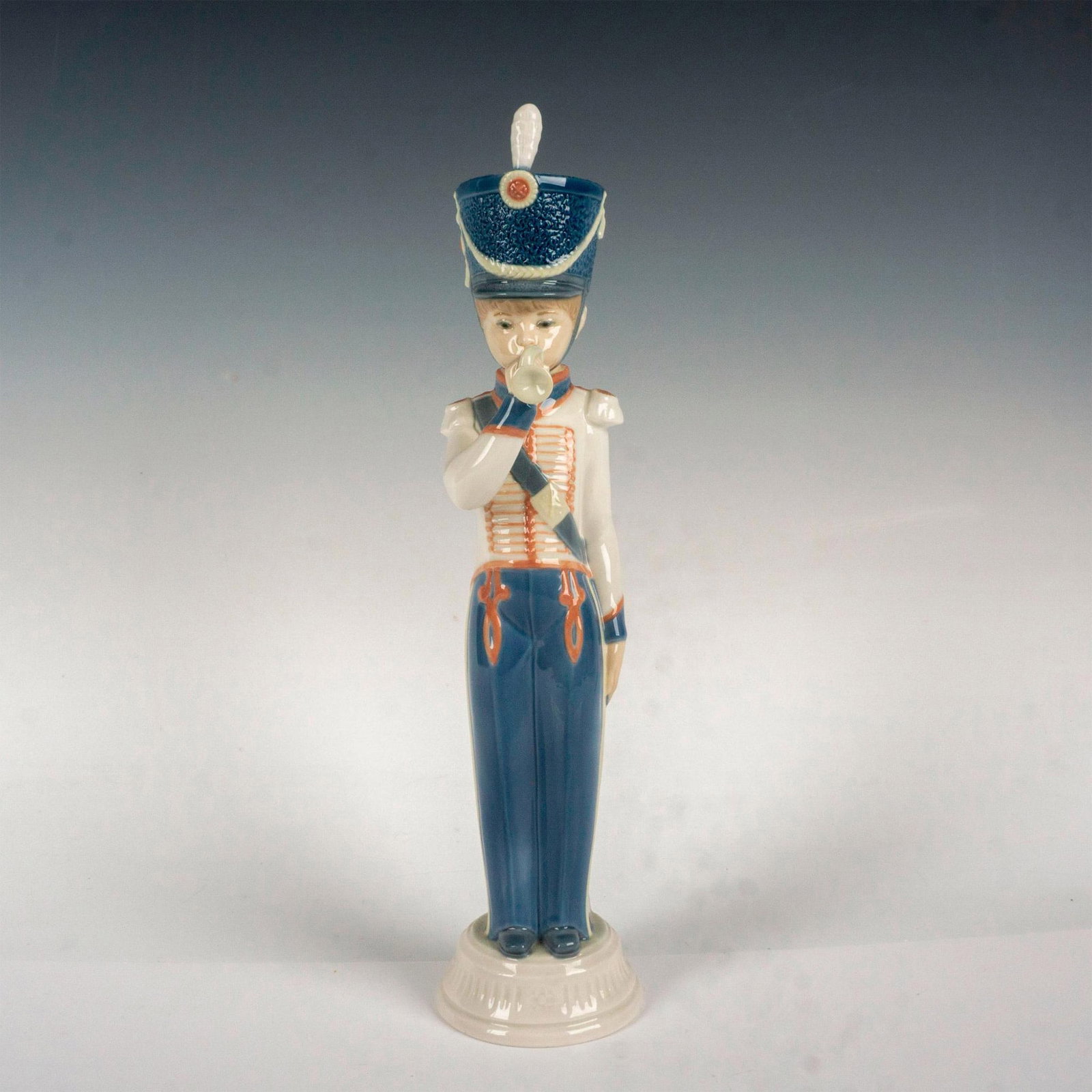 Bugler 1005406 - Lladro Porcelain Figurine: Glossy finish; Lladro backstamp. Artist: Vicente Martinez Issued: 1987 - 1989 Dimensions: 12.5"H Manufacturer: Lladro Country of Origin: Spain