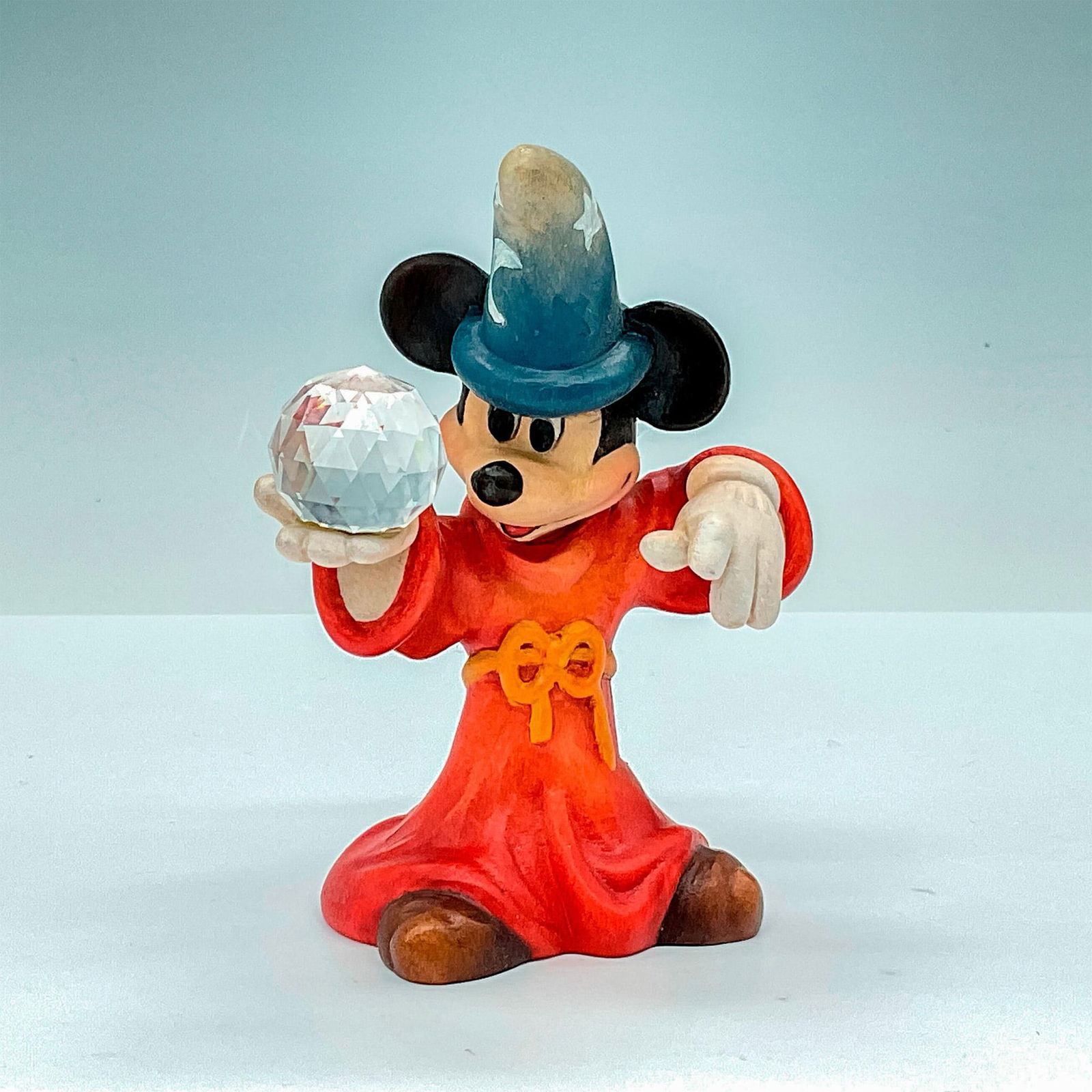 Anri Club Walt Disney Wood Figurine, Mickey Fantasia: Magical painted wooden figurine of Mickey the Wizard of Fantasia. In hues of earthy black, red, blue, and white, with Mickey holding a faceted crystal-like ball. Anri metal logo emblem affixed to base