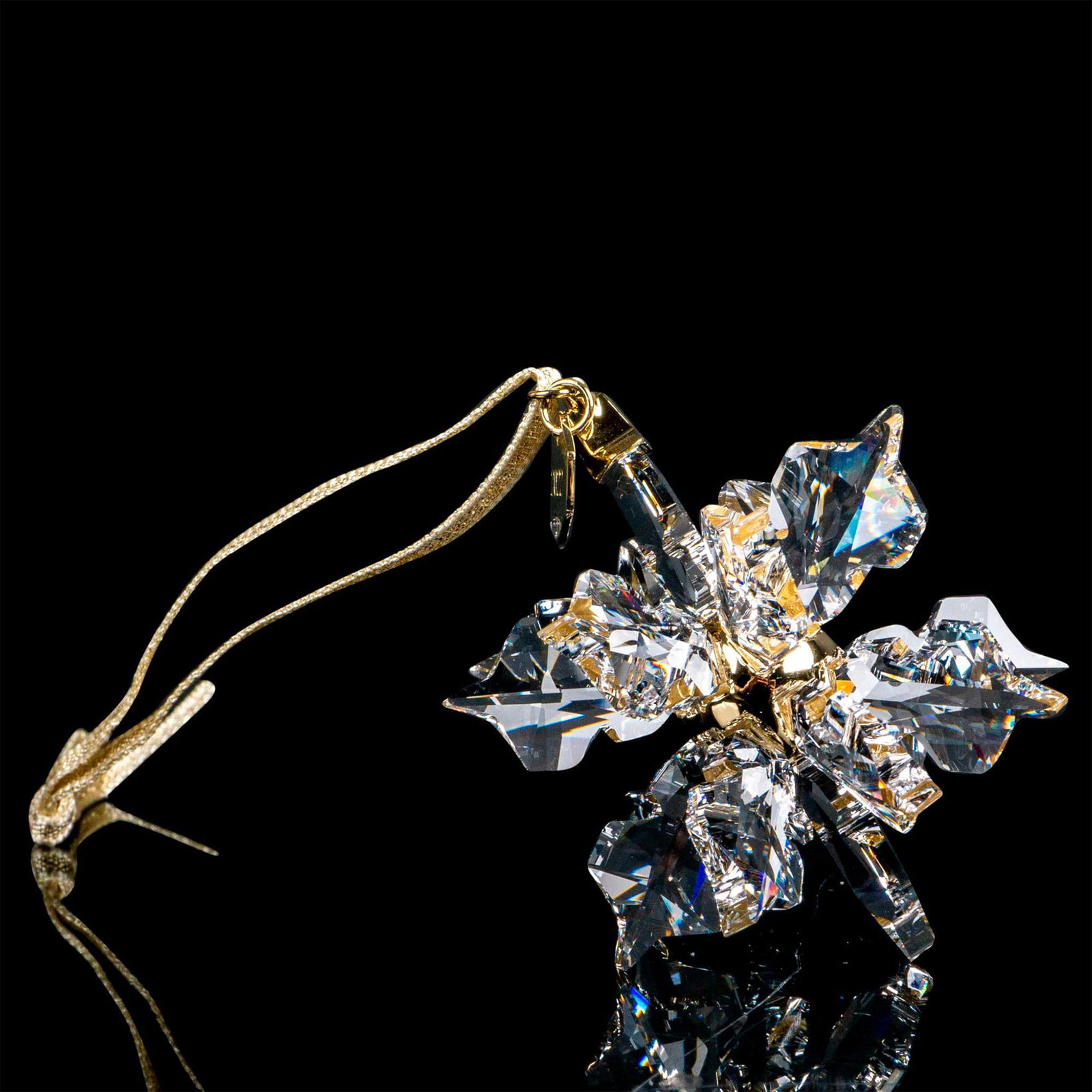 Swarovski Crystal Ornament, Annual Edition Snowflake: Lead crystal part of the Christmas Ornaments collection, made from clear crystal and hangs on a gold-tone ribbon. Swarovski etched backstamp. This item has its original box. Box measures: 3.5"L x 4.5"