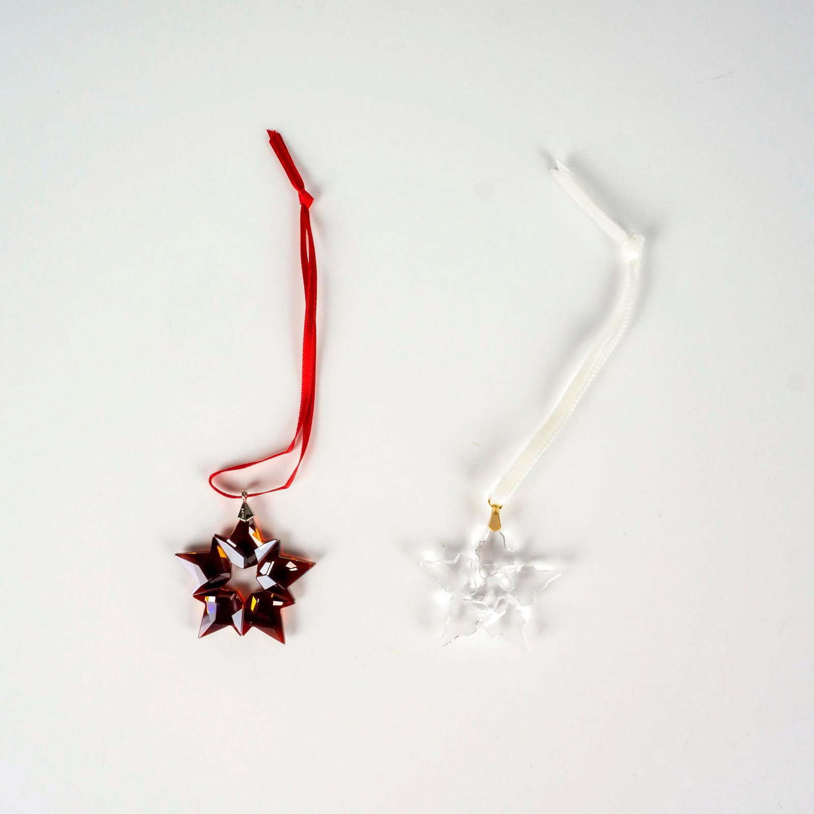 2pc Swarovski Crystal Holiday Ornaments: Lead crystal pieces part of the Christmas Ornaments collection, made from colored crystal with satin ribbons. Swarovski etched backstamp. This item has its original box. Boxes measures: 3.5"L x 3.5â�