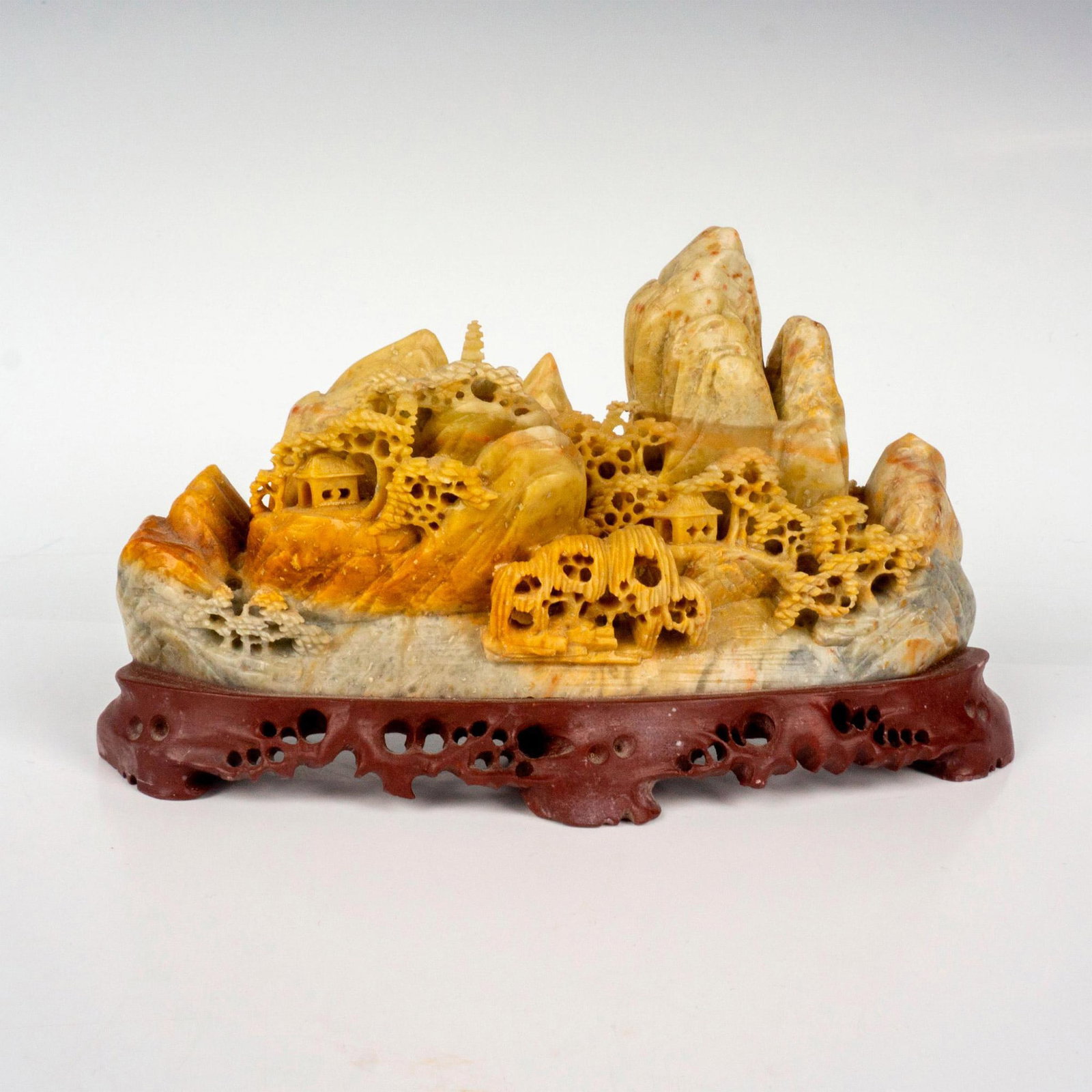 Vintage Chinese Village Mountain Sculpture: A beautiful carved soapstone depicting a village in the mountains. Attached to a burgundy soapstone base. Made in the People's Republic of China sticker on the back. Dimensions: 7"L x 2"W x 4"H Countr