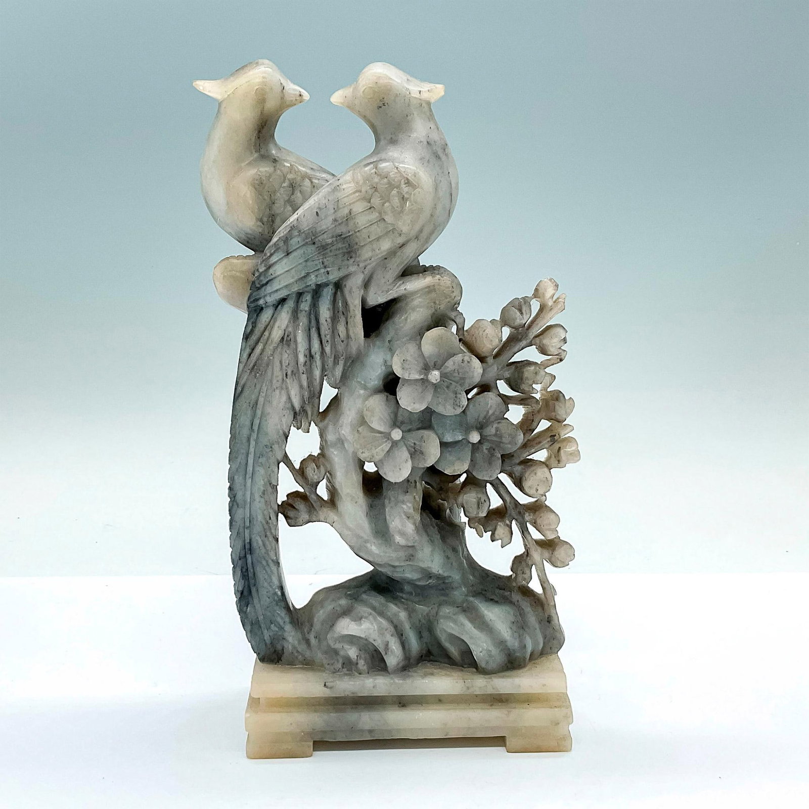 Chinese Carved Soapstone Birds Sculpture: A beautifully carved gray rock depicting two phoenixes perched on a blossom tree. Made in the People's Republic of China sticker on the base. Dimensions: 4.75"L x 2.5"W x 8.25"H Country of Origin: Chi