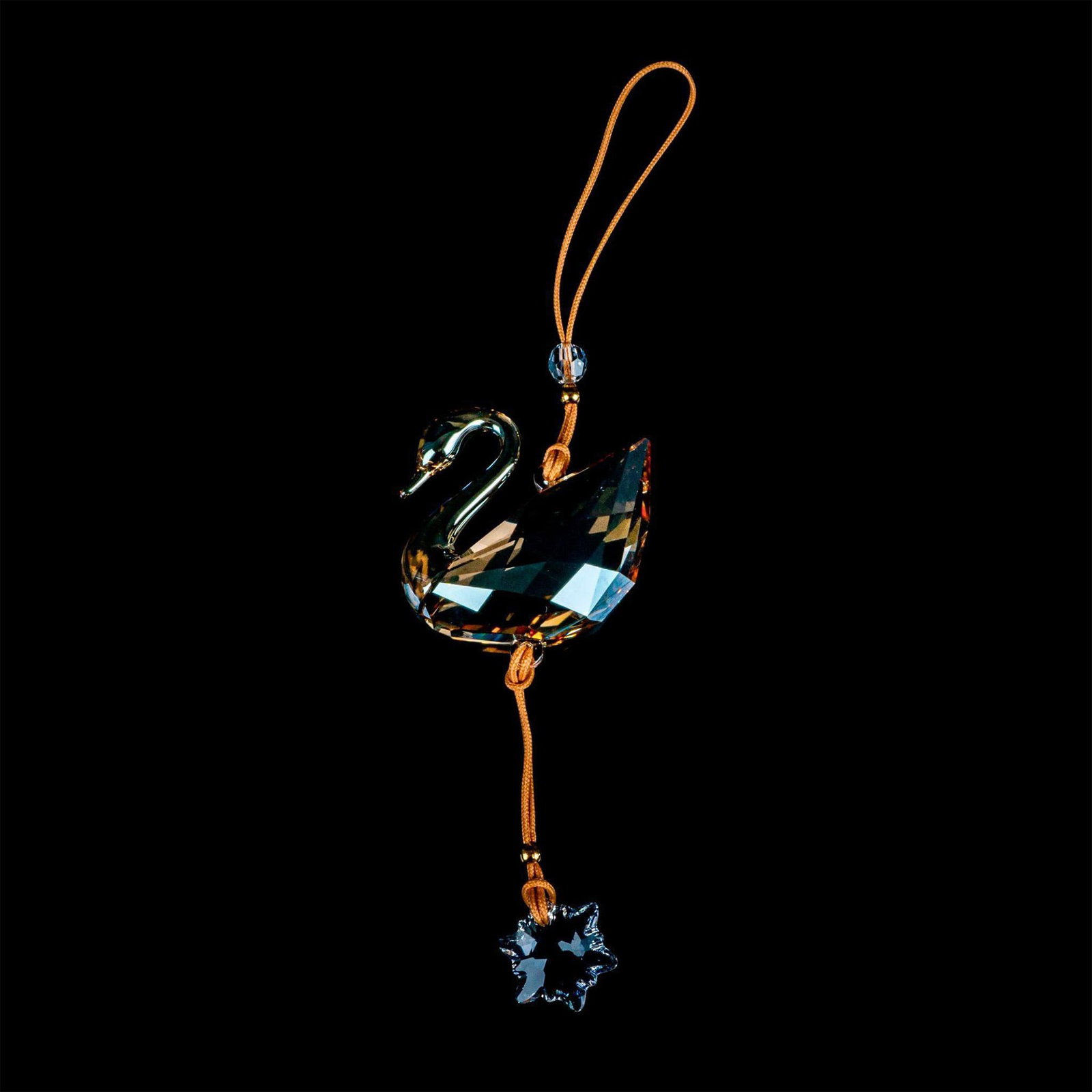 Swarovski Crystal Ornament, Swan: Delicate amber signature Swarovski swan emblem ornament with hanging snowflake. This is a Swarovski Crystal Society member's piece. Swarovski backstamp. This item has its original box. Box measures: 3