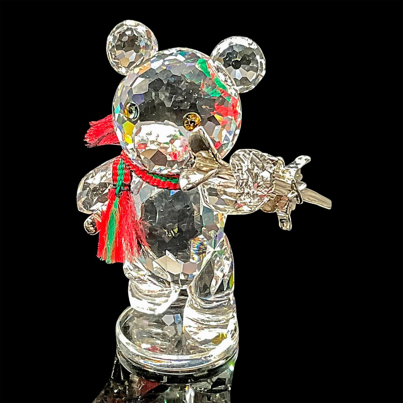 Swarovski Crystal Figurine, Kris Bear with Skis: This sparkling crystal collectible bear was part of the ï¿½When we were Youngï¿½ theme. Kris Bear with skis wears a festive ribbon of green and red fabric around his neck and carries rhodium ski
