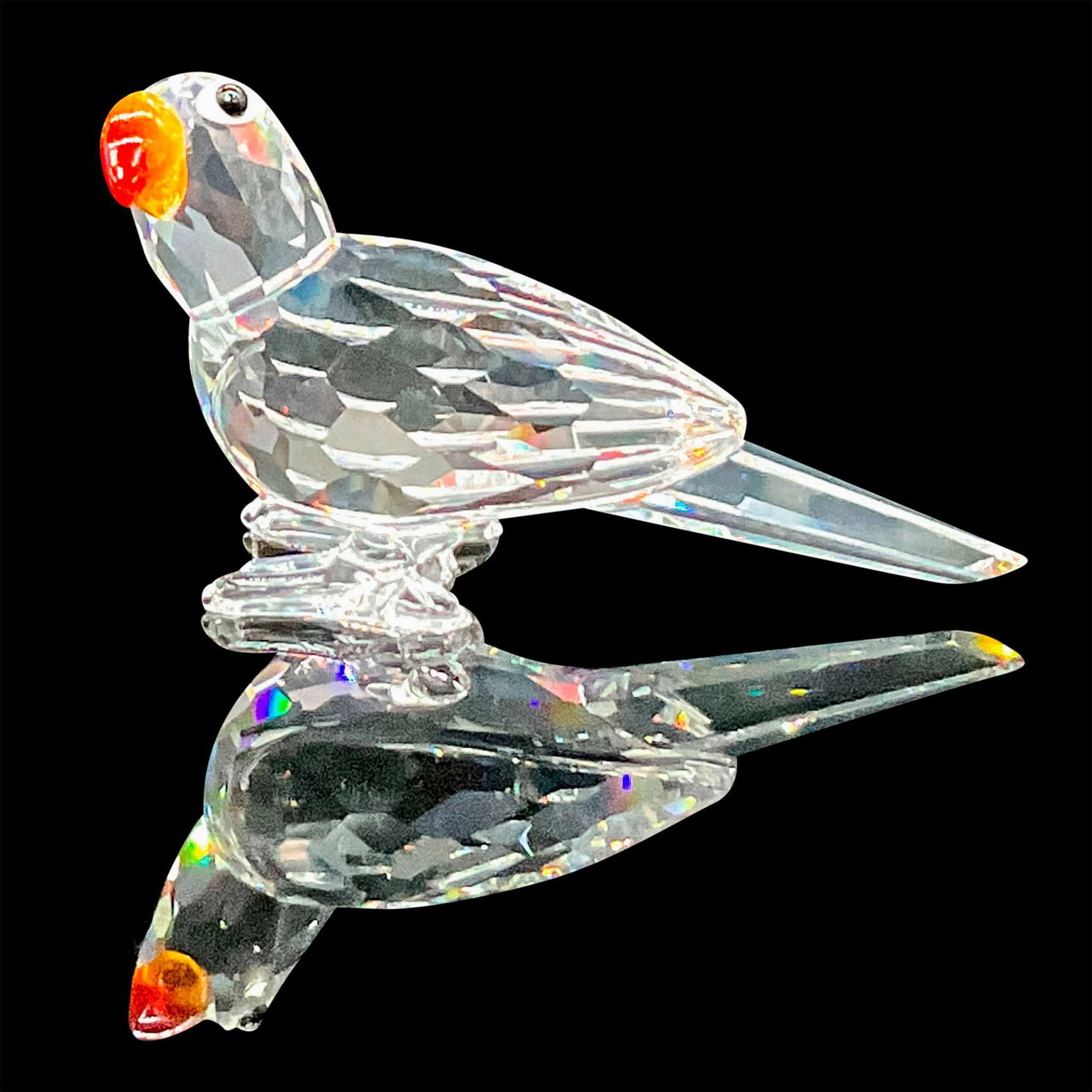 Swarovski Crystal Figurine, Parrot: Part of the 'Feathered Beauties' collection. Clear faceted parrot with black and white crystal eyes, and fire opal beak. Swarovski marking. This item has its original box: 3.25"W x 4.5"H. Artist: Mich