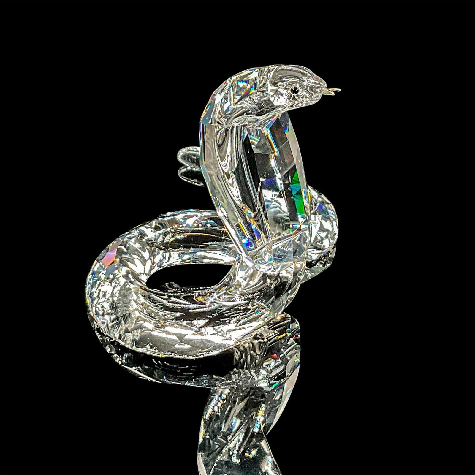 Swarovski Silver Crystal Figurine, Cobra: Brilliant clear crystal figure of a cobra posed upright with rhodium forked tongue. Swarovski etched backstamp. Includes original box 3.75"H x 4.75" dia. Certificate of Authenticity included. Dimensio