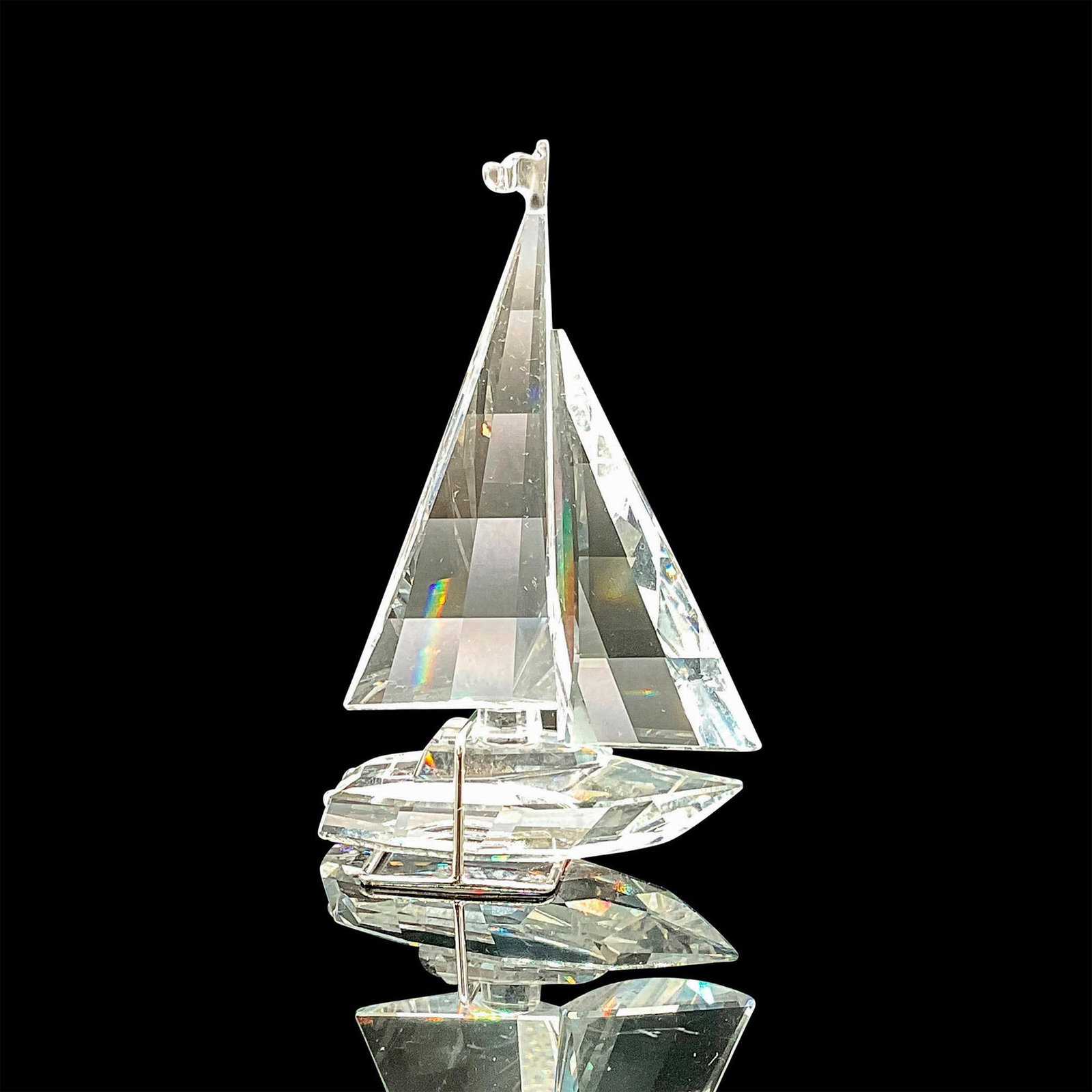 Swarovski Crystal Figurine, Sailing Boat/Sailboat: This retired Swarovski crystal sailboat was a member of the ï¿½When we were Youngï¿½ category. A rhodium metal stand is included with the sailboat for additional stability. This item has its ori