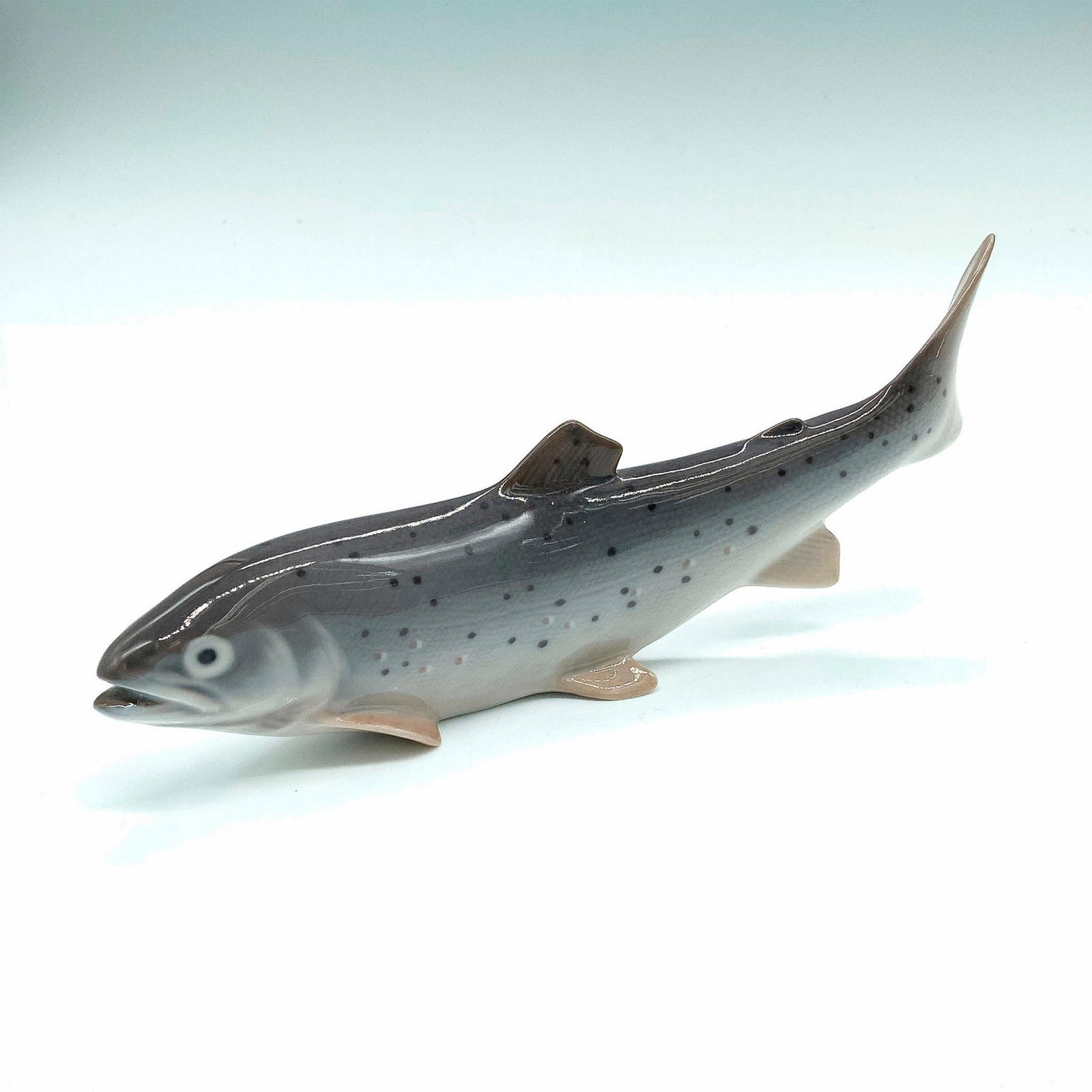 Royal Copenhagen Figurine, Trout Fish 2676: Blue and grey coloration; glossy finish. Royal Copenhagen mark on bottom. Dimensions: 8"L x 1"W x 3.25"H Manufacturer: Royal Copenhagen Country of Origin: Denmark