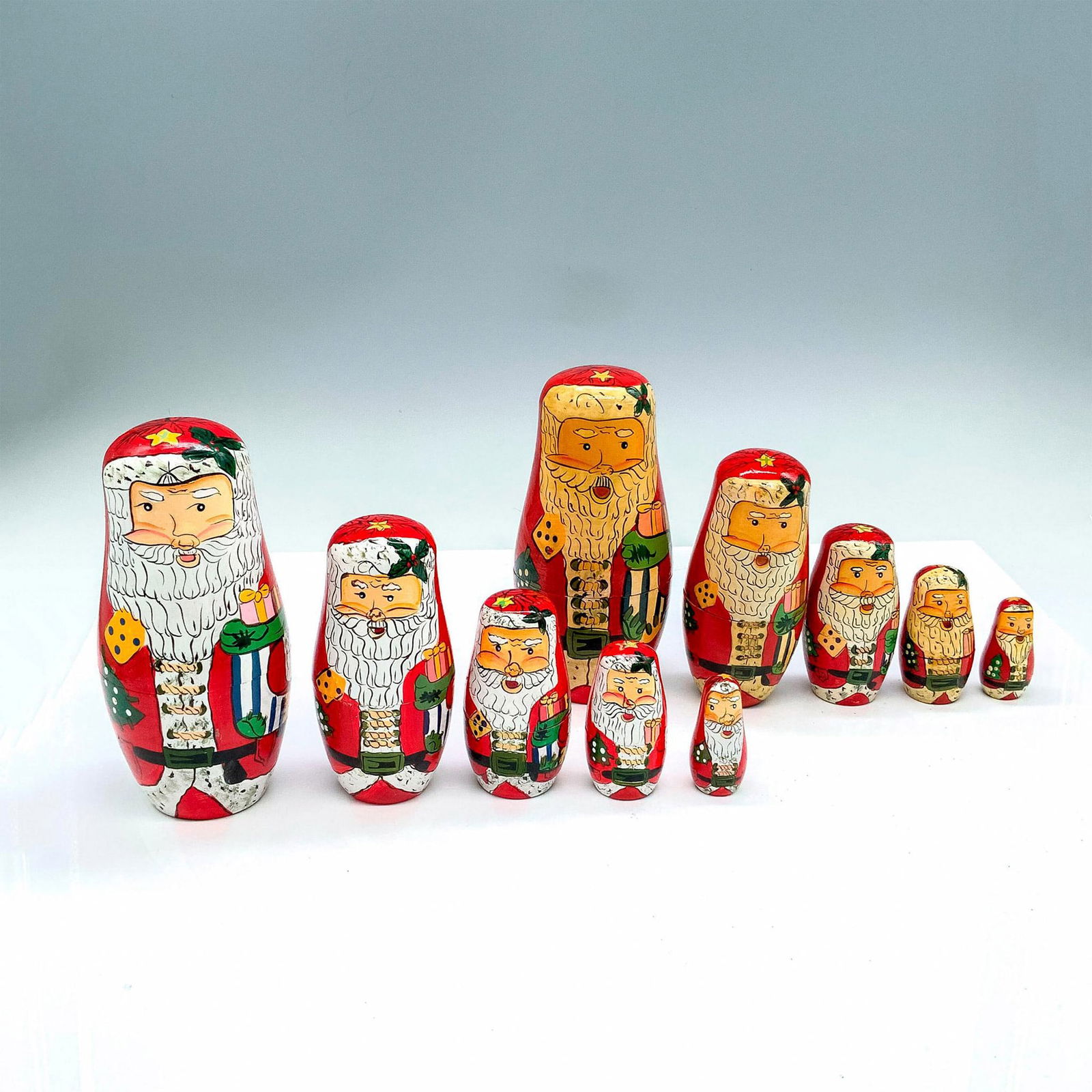 Two Holiday Christmas Santa Claus Nesting Dolls: Each set has four smaller dolls inside the largest one for a total of five. Second largest doll in one of the sets is difficult to close. Dimensions: 2.5"dia. x 5.5"H