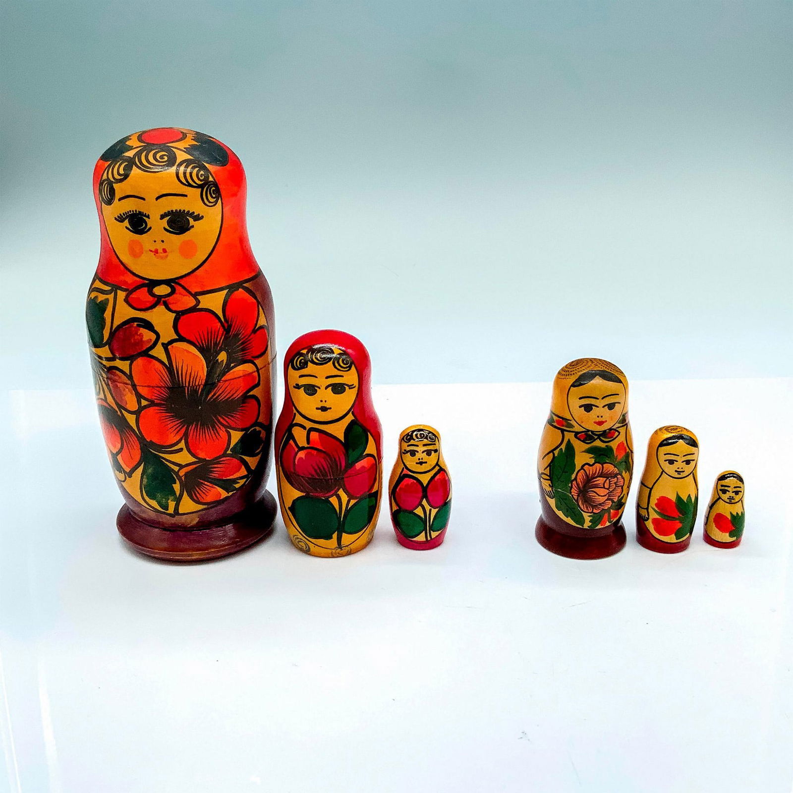Two Vintage Colorful Wooden Russian Floral Nesting Dolls: Biggest doll in the larger set has two other dolls inside it and measures 2.5"dia. x 5.75"H. Biggest doll in the smaller set has two other dolls inside it and measures 1.25"dia. x 2.75"H.