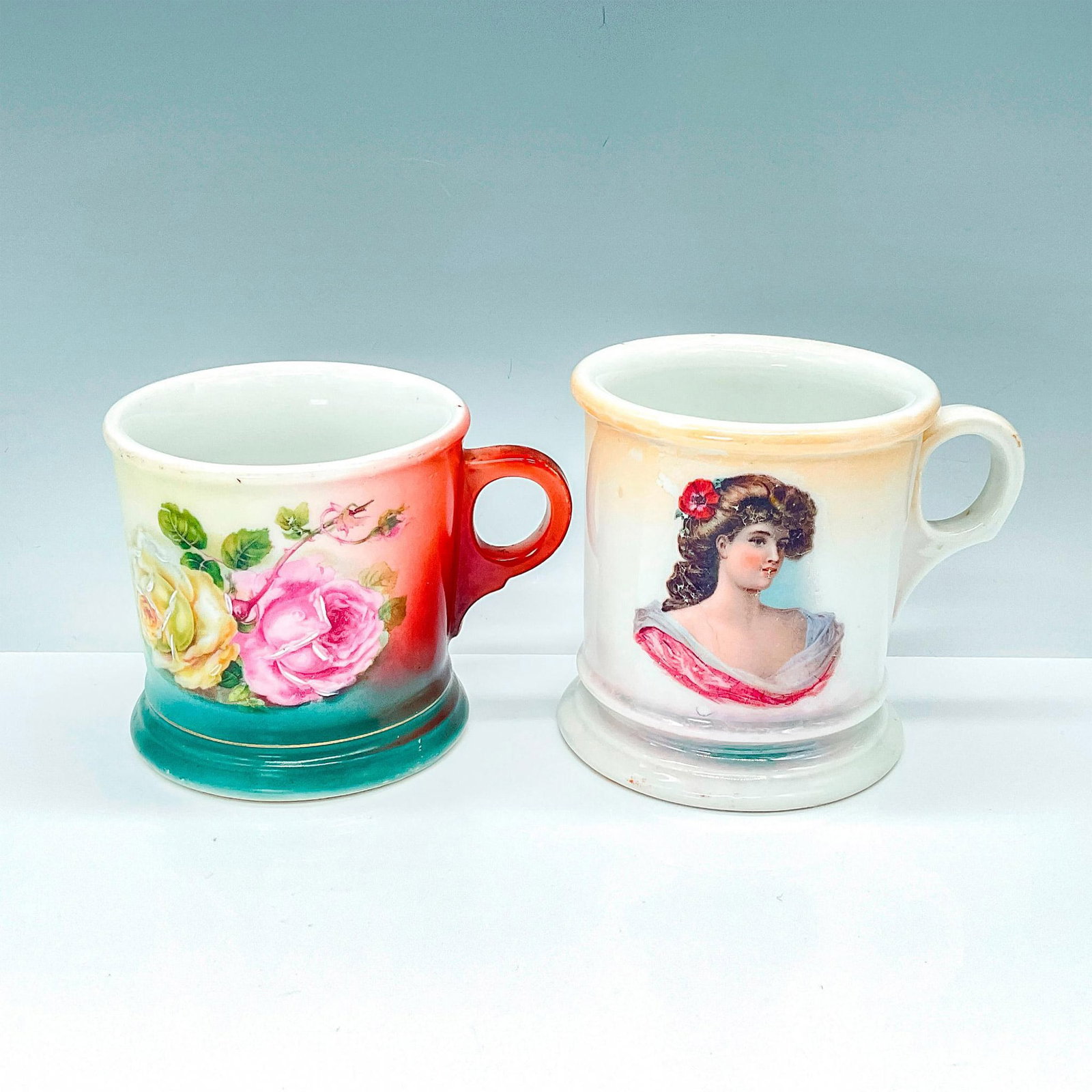Pair of Shaving Cream Mugs: Two robust porcelain shaving cream mugs, each adorned with decorative designs and distinctive stamps. One hails from Germany, while the other is from Altwasser Silesia. Largest piece measures 4.75"L x